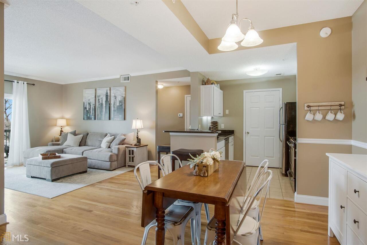 Wonderful two bedroom corner unit in the heart of Midtown! Gorgeous hardwood floors lead you in from the foyer to the welcoming gathering spaces. Wide open dining area easily flows into the living room and kitchen featuring timeless white cabinets and stone countertops with stainless steel appliances. Just off the kitchen is a private, in unit laundry room with extra storage space. This split bedroom floorplan is perfect for guests, roommates or working from home! Master suite features tons of natural light, a nice walk-in closet and private, en-suite bathroom.The large secondary bedroom offers double closets and direct access to the secondary bath. Both bathrooms have been updated with granite countertops, framed mirrors and recently painted cabinets. Unit B401 is located in the preferred community building where the pool, fitness center, package room, and HOA offices are located. Two covered parking spots for homeowners and tons of guest parking. You cannot beat this value intown with low HOA fees (only $290/month!) in the heart of the vibrant Midtown neighborhood only blocks from Piedmont Park, the Beltline, MARTA and countless boutiques, restaurants, and grocery stores. Welcome home to Peachtree Walk!