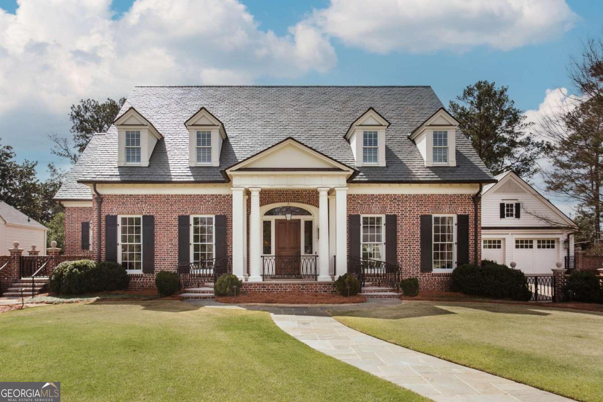 Welcome to 585 West Cloverhurst Avenue. This magnificent custom-built home sits on a premier street in the highly sought-after Five Points neighborhood located in Athens, Georgia. Every fine detail of this home thoughtfully executed and meticulously maintained. The welcoming front portico with beautiful ironwork and limestone leads to a grand foyer with hidden closets, hinting to all the special details and large scale proportions of this home including incredible wood work and fine finishes. Gorgeous wide plank oak floors throughout much of the home. Comfortable study with warm reclaimed heart pine from a Georgetown, South Carolinian pre-Civil War factory. This cozy room features other details like built-ins, coffered ceiling and French doors leading to sitting porch with brick, bluestone and ironwork details. Stylish powder room with uniquely designed sink cabinet and artful, handmade one-of-a-kind light fixture above. Handy wet bar with fridge and ice maker. Lovely formal dinning room with beautiful wood and glass cabinetry opposite side of foyer which leads to large Butlers pantry / scullery and full walk-in hidden pantry, all with custom cabinetry and plenty of shelving / storage. Stunning light and bright entertainers kitchen with marble counter tops, a multitude of handmade cabinets, professionally rated high-end appliances including Subzero side-by-side refrigerator / freezer and gas Wolf range with griddle, huge exhaust hood as well as warming drawer. Additionally, this open space has hand carved wood accents, Rocky Mountain hardware, shiplap walls, gorgeous and generous accent island with hand-carved walnut top and bar seating. This space accommodates a large table for gathering and leads to a sunny sitting room for chatting or watching TV. Big laundry room with sink, office area and limestone flooring. Spacious 2 car garage attached and side door exit. A grilling porch with built-in Wolf grill adjacent. Stunning great room with large scale French doors leading to back patio with bluestone flooring and custom designed ironwork overlooking fenced backyard. Lovely wood burning fireplace with gas starter, nearly 12 foot coffered ceiling and carved wood accents as well as impressive archways and crystal chandeliers add layers of interest to this room. Owners suit on main floor offering a private and spacious retreat with spa-like bathroom including double vanities, soaking tub, walk-in shower and separate water closet with bidet. Generous divided closet spaces for two. Other features of main floor include elevator serving all three floors of this home, security system, built-in speaker system with surround sound, solid brass hardware and pulls, solid wood doors and cabinets as well as other unique designer touches. Upstairs two spacious sunny bedrooms with ensuite bathrooms and large custom walk-in closets. Plenty of extra storage spaces on this floor as well. Large flex room with built-in cabinets and desks that could be converted into a third bedroom or used for media or playroom. Sunny terrance level has spacious office, exercise room, powder room and another great room with 10 foot ceilings and hardwood floors. Stone fireplace with gas logs, built-ins and surround sound speakers. French doors lead to outdoor covered seating area. Full designer kitchen with rainforest marble countertops, more customer cabinetry with plenty of storage, as well as a full range of appliances. Dinning space as well as game room or more separate formal dining area. Second two-car garage with storage room off this lower level. Full additional light and bright bedroom with marble wet bar and full bathroom including zero step walk-in shower and water closet. Large closet. Additionally, there are several secure rooms for a multitude of uses. Outdoors includes professional landscaping, irrigation with well and accent lighting. Home features custom lightening, Flemish brickwork, cypress woodwork, copper gutters and slate roof.