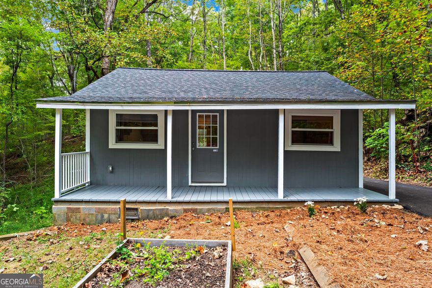Tucked away on just over an acre of land, this charming two-bedroom, one-bath cabin offers the perfect blend of comfort, nature, and simplicity. Surrounded by trees and open space, it's a quiet retreat where mornings begin with birdsong, evenings end under the stars, and life moves at a slower, more intentional pace, all while being just minutes from local shops, dining, and the small-town charm of Ball Ground and Jasper. Thoughtfully cared for and updated, this property is truly move-in ready. Key improvements include a roof and split HVAC unit replaced in 2020, a bladder tank replaced in 2021, a paved driveway completed in 2024, and a well pump replaced in 2025. Each update reflects consistent maintenance and pride of ownership. Inside, the home features an open, functional layout filled with natural light. The kitchen and living spaces flow comfortably, creating a relaxed and efficient feel throughout. The washer, dryer, and refrigerator all remain with the home, making your move easy and stress-free. Step outside to enjoy the peaceful setting, space for a garden, a few chickens, or simply a place to sit and unwind. Whether you're looking for a full-time residence, a weekend getaway, or a simple place to slow down and reconnect with nature, this property offers a wonderful opportunity at an affordable price.