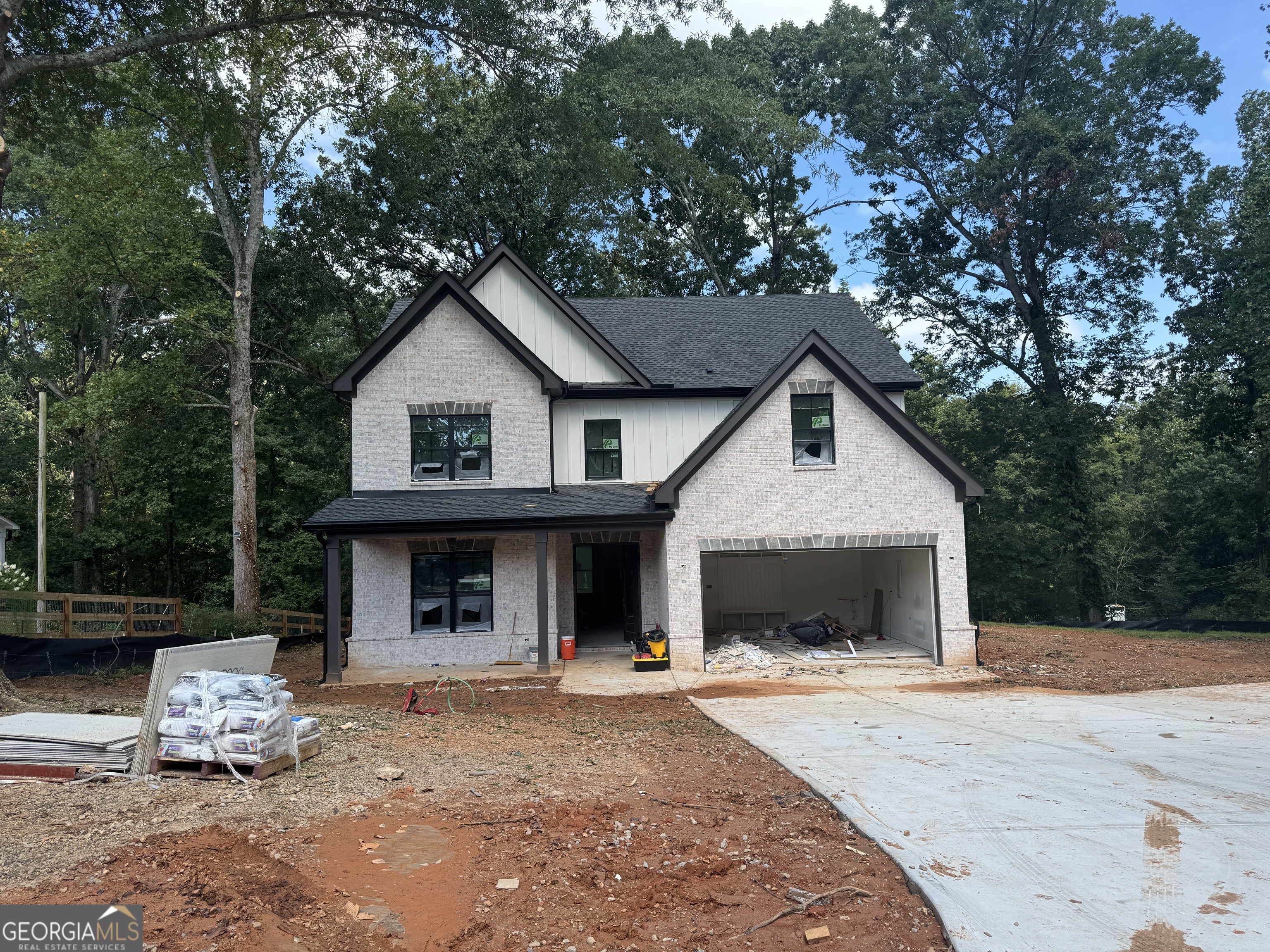 Welcome to your dream home! The brand- new modern farmhouse is nestled in the highly sought after Buford City School district. Located steps from Lake Lanier and close to downtown Buford, shopping and dining. Step inside to an open concept layout featuring 10 ft ceilings and gorgeous hardwood floors throughout the main level. The bright and open dining room flows into a cozy family room perfect for everyday living and entertaining. The chef inspired kitchen is a showstopper with a designer backsplash, soft-close cabinetry, stainless steel appliances and a breakfast nook with built-in seating. A guest bedroom and full bathroom are also located on the main level ideal for a home office or in-law suite. Upstairs, retreat to a serene owner's suite featuring a tray ceiling, soaking tub, separate shower and dual vanities. The massive walk-in closet features custom shelving and cubbies. The upper level also includes three spacious secondary bedrooms, a loft/media room, a laundry room and a full bathroom. Enjoy the peaceful private back patio surrounded by nature. Don't miss this rare opportunity to own a beautifully designed new home in one of Buford's most desirable locations. Schedule your showing today!