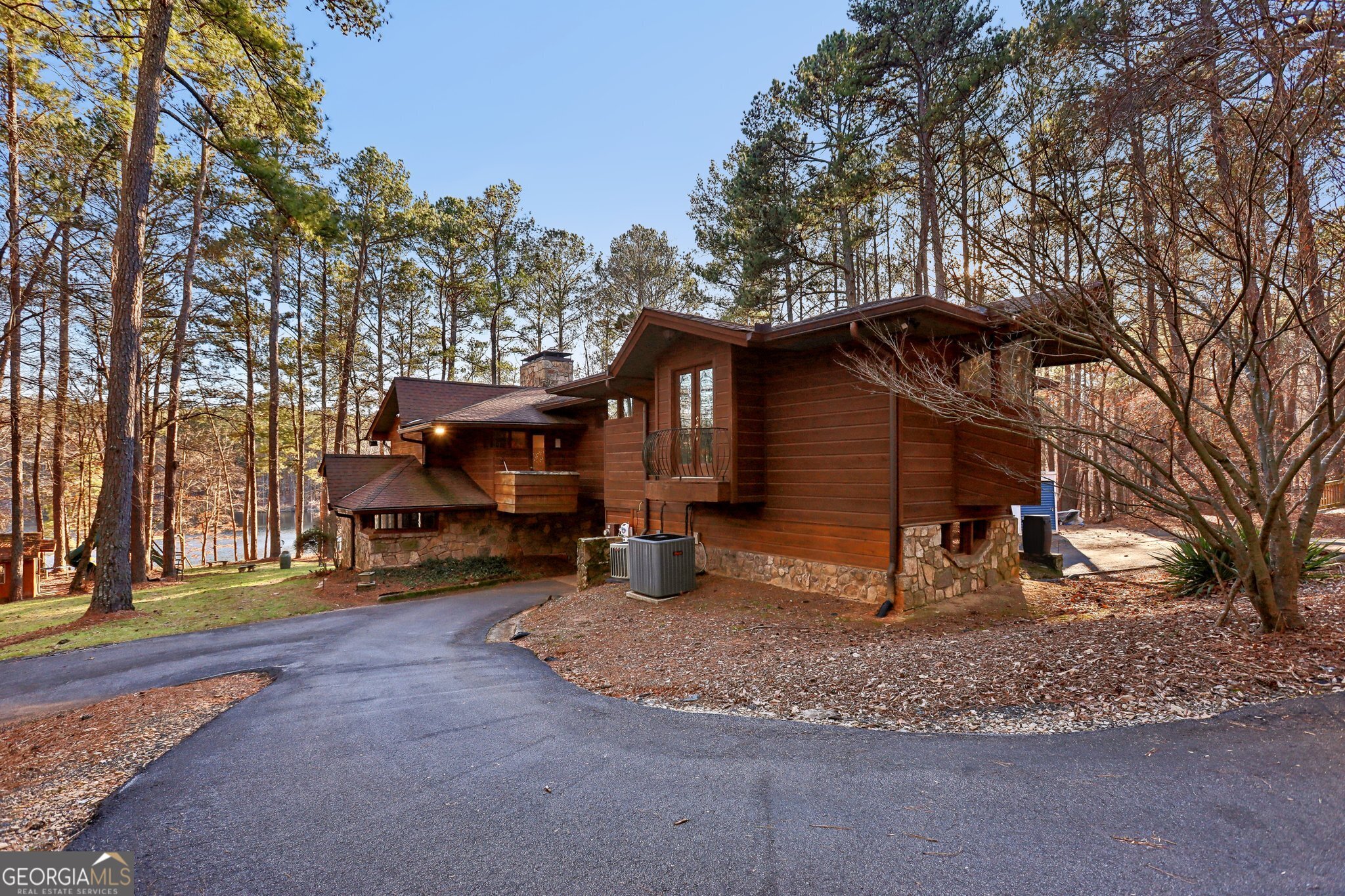 Escape to Your Private Retreat! Discover unparalleled tranquility in this custom-built, cabin-inspired home, nestled on a secluded waterfront lot. This exquisite 4-bedroom, 3-bathroom residence offers a sanctuary of refined comfort. Imagine waking up to serene water views from nearly every room. Two bedrooms feature charming walk-out decks, perfect for morning contemplation. The primary suite is a true haven, boasting dual closets, a cozy fireplace, a large bathroom with a soaking tub, separate shower, and a double vanity. The primary also has a private office and separate sitting area, connected to a dedicated staircase leading to a versatile lower-level retreat (man cave), complete this luxurious space. Entertain effortlessly in the open-concept dining and kitchen areas, or unwind in the inviting family room with its wood-burning fireplace and bar. The sun-drenched glass sunroom offers panoramic water views, ideal for savoring moments of peace. Step outside onto the expansive deck and enjoy direct access to the water for small boating adventures. Conveniently located near Panola Mountain State Park, this home offers a perfect blend of natural beauty and modern convenience. ALL while being close to the city!