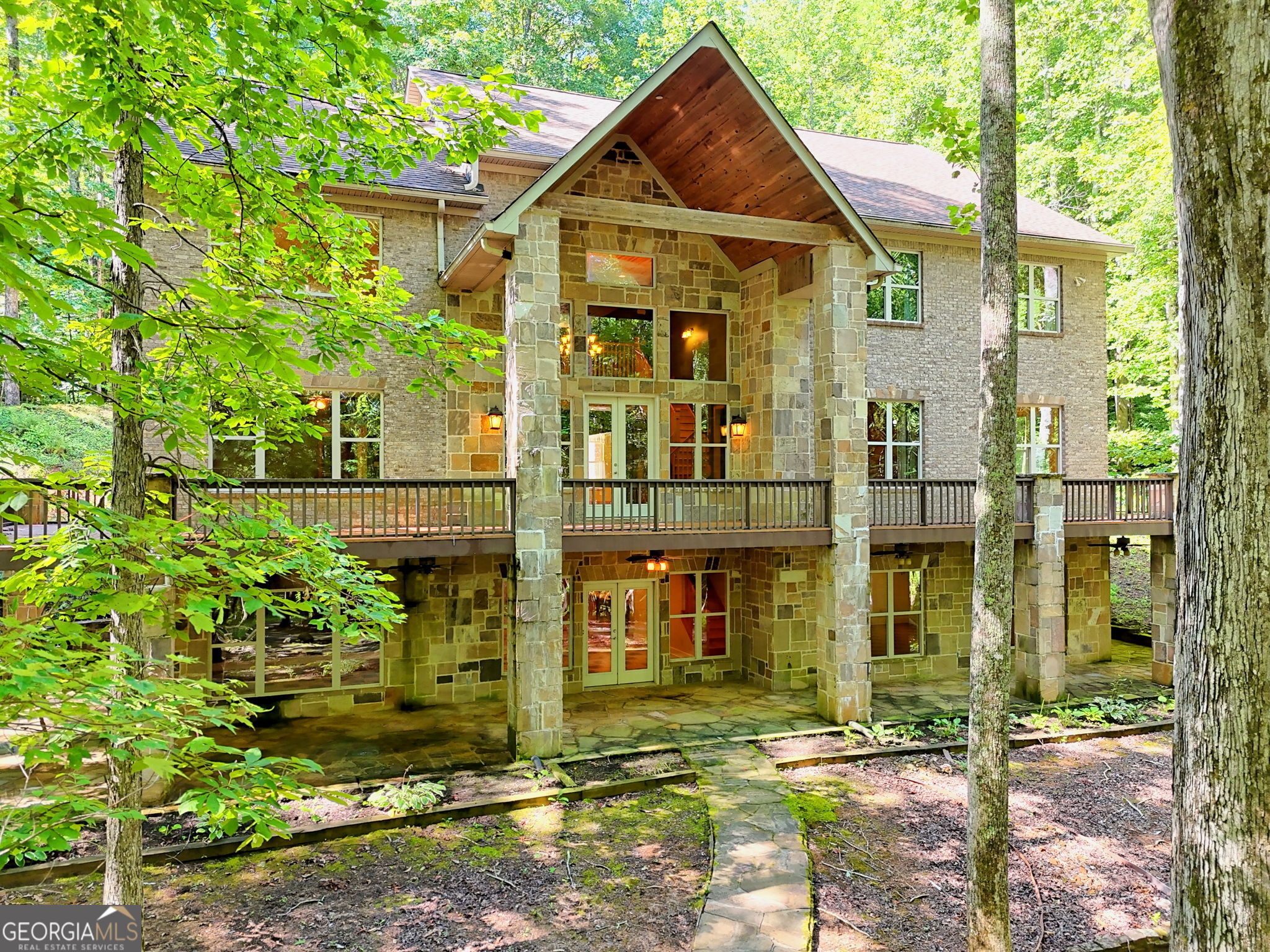 Begin relaxing as you slowly start up the private drive to this stunning custom brick/stone mountain retreat in Chinkapin at Burton! Enjoy 10.54 acres ( 2 additional lots 26 & 27 are included in this sale) of natural beauty w/seasonal views & a quiet serene walking path surround the property. This home offers 6 bedrooms/4 full baths complete w/an elevator to easily take you to each of the 3 floors. The great room boasts a massive stone fireplace & flanking built-ins, large windows & French door leading to wrap around deck. GR opens to the kitchen w/built-in stone breakfast bar & stone arched vent hood, granite, plenty of cabinets & serving space, walk-in pantry. Laundry room is adjacent to kitchen. Owners suite is on the main floor w/en-suite featuring double vanities, double showerheads, separate tub & walk-in closet w/California closet system through out home. Split spacious bedrooms share jack-n-jill baths. Entire home is handicap accessible w/entrance ramp, wide doors/halls, roll-in shower, lower bathroom vanity & elevator. Upstairs has 2nd large den area overlooking main level, home office, spacious bedrooms, jack-n-jill bath & space for a bunkroom. Lower level presents large 3rd entertaining space w/bar area, pool room, huge 6th bedroom & 4th bath. Storage closets, 2 mechanical rooms with two water heaters, storm room, french doors open onto wrap-around terrace level. Circular driveway. This home has been lovingly maintained and is the perfect home to host lots of friends and family in the beautiful mountains. Plenty of wildlife abounds. Close to beautiful Lake Burton, kayaking, hiking, dining/restaurants, Waterfall at Burton. DON'T FORGET: Adjoining lots 26 & 27 are included in this sale for a total of 10.54 acres!!! Don't miss seeing this home...you won't be disappointed!!!