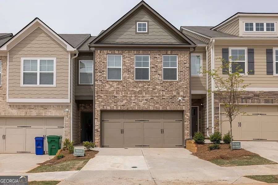 Welcome home to this modern townhome with a charming brick front exterior and an inviting open-concept design. The main level is perfect for everyday living and entertaining, featuring a spacious family room with a cozy fireplace that flows into the bright kitchen with a large island breakfast bar, crisp white cabinets, a pantry, and a generous dining area where everyone can gather. Upstairs, the owner's suite offers a peaceful retreat with a tray ceiling and a spa-like en-suite bath complete with a double vanity, soaking tub, and separate shower. The secondary bedrooms are comfortably sized, making them ideal for family, guests, or a home office. Step outside to enjoy the level fenced backyard with a patio, perfect for relaxing evenings or weekend cookouts. All of this in a convenient location just minutes from Covington Highway and Panola Road, with easy access to I-20 and I-285 for quick commutes around the city.