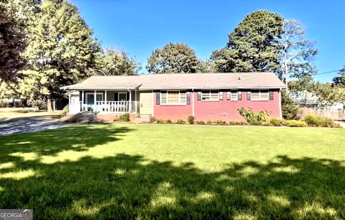 Charming 3BR/2BA Ranch with Detached Garage & Workshop! Welcome to this cozy ranch home ideally located on a quiet street just minutes from Hwy 78, Hwy 124, I-285, shopping, dining, and the scenic Stone Mountain Park. This well-maintained 3-bedroom, 2-bathroom home offers a bright and airy family room with laminate flooring and a cozy fireplace. A separate formal living room provides the perfect setting for gatherings or quiet evenings. Sitting on a beautifully landscaped 0.41-acre lot, the property features fruit trees, a fully fenced backyard, and a spacious deck perfect for outdoor entertaining or relaxing. You'll also appreciate the detached 2-car garage with an attached workshop, ideal for storage, hobbies, or weekend projects.