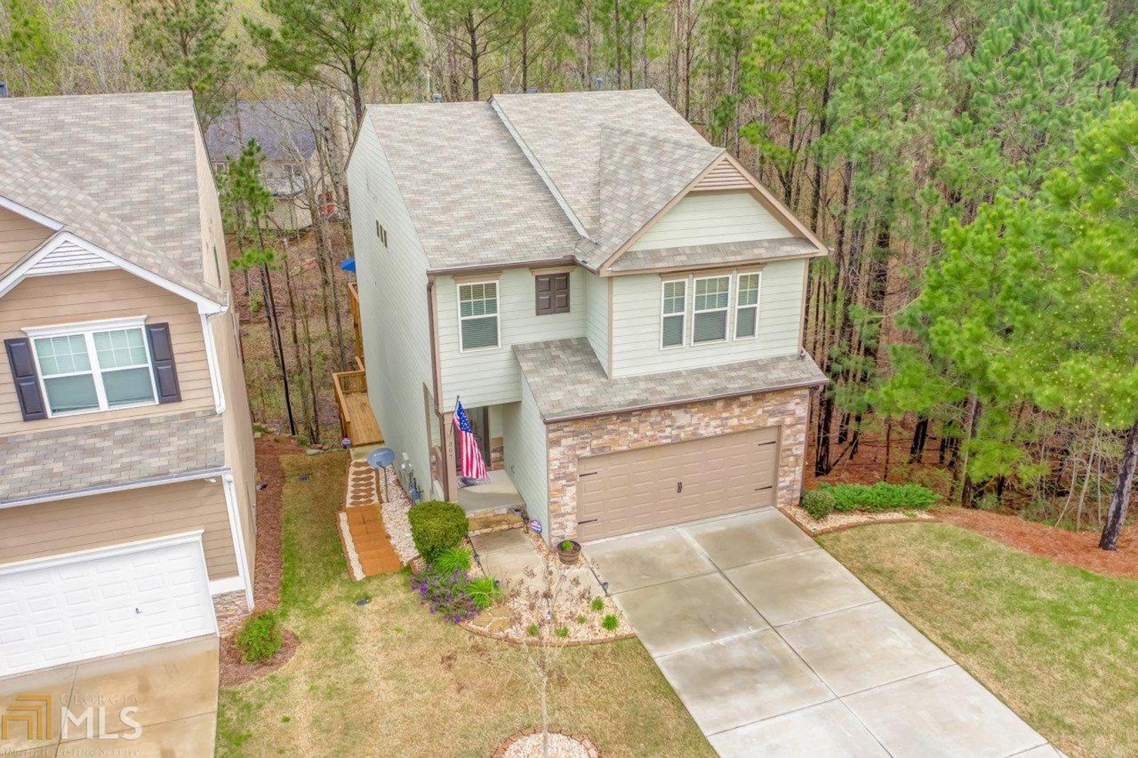 Are you looking for newer construction in Woodstock without paying a fortune? Here is your opportunity. Gently lived in meticulously maintained home built in 2016. One of the larger floor plans. Home features hardwoods throughout the main floor, spacious island kitchen with granite, large pantry, family room with gas fireplace, dining area, main floor and lower level rear deck facing the woods for privacy. Upstairs you will find 4 spacious bedrooms, large owner's suite, tiled owner's bathroom with separate shower and tub, double vanity, walk in closet, huge walk in laundry room. Staircase has wrought iron spindles, unfinished terrace level is ready to be finished or makes great storage, stubbed for a full bathroom. Gutter guards recently installed. Stone stairs on the side of the home to the terrace level. HOA maintains the yard for you so you can enjoy living without to the hassle. You will appreciate how close you at to shopping like Super Target, BJ's Warehouse, Kohl's, Home Depot/Lowes, The Outlet Shoppes of Atlanta, Downtown Woodstock, Hwy 575 and much more.
