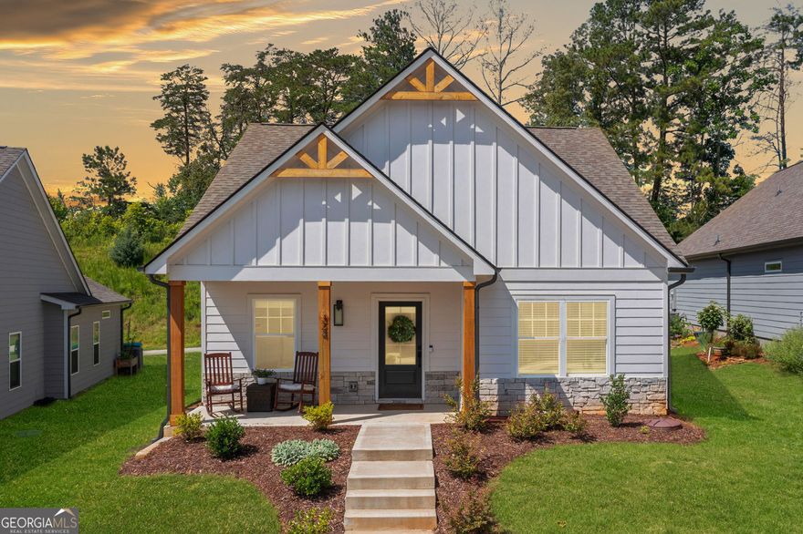 Welcome home to this sought-after ranch plan that blends comfort, style, and convenience all on one level. This well-designed home has 3 bedrooms and 2 bathrooms. It includes a covered front porch and a rear porch. Both are great for your morning coffee or relaxing in the evening.  Step inside to find a gorgeous kitchen. It showcases white cabinets and solid surface countertops. There's also undermount lighting and stylish pendant lights. The working island flows into a spacious dining area. The seamless flow into the large family room creates an inviting space to gather, complete with a cozy gas fireplace with direct vent and gas logs.  Escape to the Primary suite.  Enjoy the oversized tile shower and elegant ceramic tile flooring in the en suite bath. The additional two bedrooms offer flexibility for guests, home office, or hobbies.  In the main living areas, laundry room, and secondary bathroom, the luxury vinyl plank flooring is both durable and beautiful.  You're just a short walk from charming Downtown Ball Ground. Enjoy local restaurants, unique shops, and community events nearby. This home offers an ideal blend of modern comfort and small-town living. Come see why this is the perfect fit for your lifestyle.