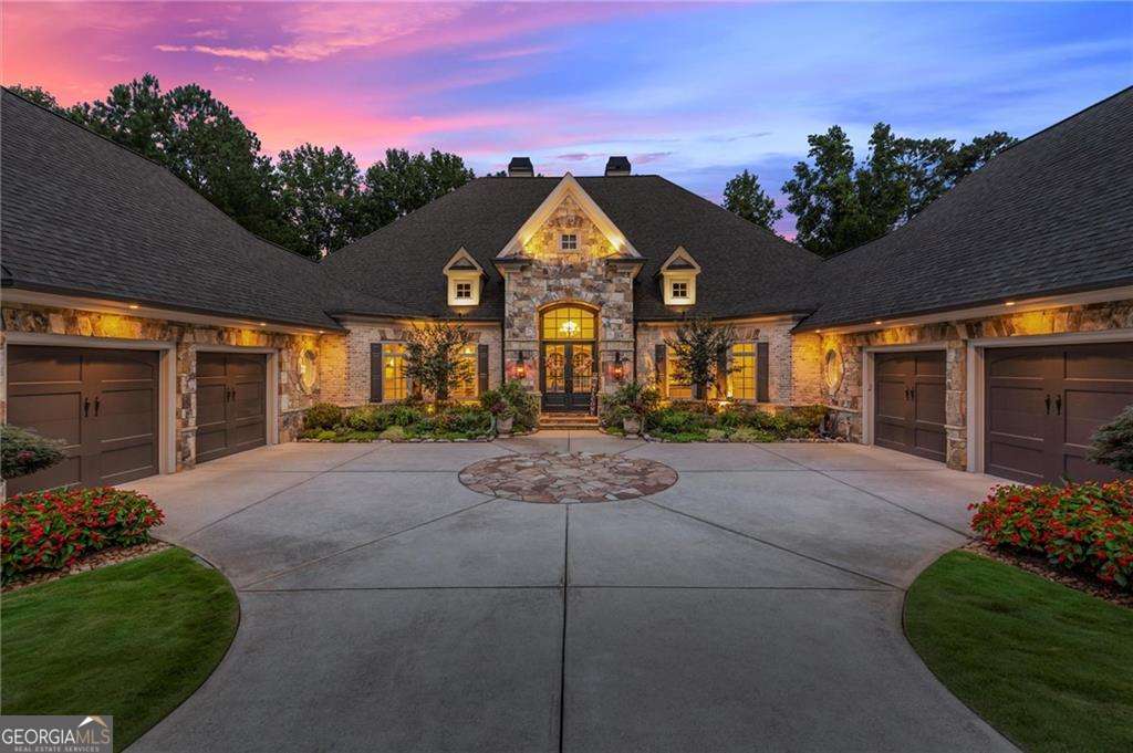 From sunrise over Bryon Lake and the 6th Fairway, to evenings outdoors by the pool and spa...discover one of the most coveted lots in gated Echelon community-enjoy the best of Milton/Alpharetta living all while enjoying the tax benefits in Cherokee County. Explore over 10,000 sq ft of thoughtfully curated and freshly updated space and design at 285 Traditions Drive. This beautifully appointed, all-brick and stone ranch offers unparalleled golf course and lake views and so much more. Distinguished features and millwork throughout and a "better than new" updates list will not disappoint! Inviting and grand, double-door entry flanked by stunning landscape opens to elegant dining and fireside living spaces, framed by a wall of windows that capture the resort-style backyard and welcomes you home. At the heart of the home, the chef's kitchen is impressive with exposed wood beams, a custom island and range hood, quartz countertops, Wolf and Sub-Zero appliances, dual dishwashers, and a spacious walk-in pantry. Enjoy a seamless flow into the fireside keeping room and outdoors to the vaulted covered porch with fireplace and dining terrace. Casual dining in the wonderful breakfast area with exquisite water feature and it's own wet bar with ice maker and custom cabinetry. The main-level Primary Suite is a retreat of its own, with a sitting room, private coffee/cocktail bar, cozy fireplace, and spa-inspired bath featuring a soaking tub, double walk-in shower, and his-and-her custom closets. Two additional bedroom ensuites round out the main level, along with a spacious laundry and stylish half bath. Upstairs, a private flex space awaits-perfect for a teen suite, office, or studio. The finished terrace level is an entertainer's dream: fireside family room, billiards area, full kitchen with dining, and a spectacular sommelier's tasting lounge for wine and whiskey gatherings. Two additional bedrooms, a half bath, laundry, and dual, his & her, poolside tiled baths + incredible storage space, complete this level. Outdoors, a true resort oasis awaits with lush landscaping, stone pathways, saltwater pool and spa, covered and open-air patios, and dramatic evening illumination. 4 car garage. Echelon offers a beautiful Rees Jones designed golf course and clubhouse- this is more than just a home, it's a lifestyle. Extensive list of Fresh Updates and Upgrades(too many to list here) + Seller's Disclosures available upon request. Reach out today for more information and an exclusive tour. Don't miss this rare opportunity!