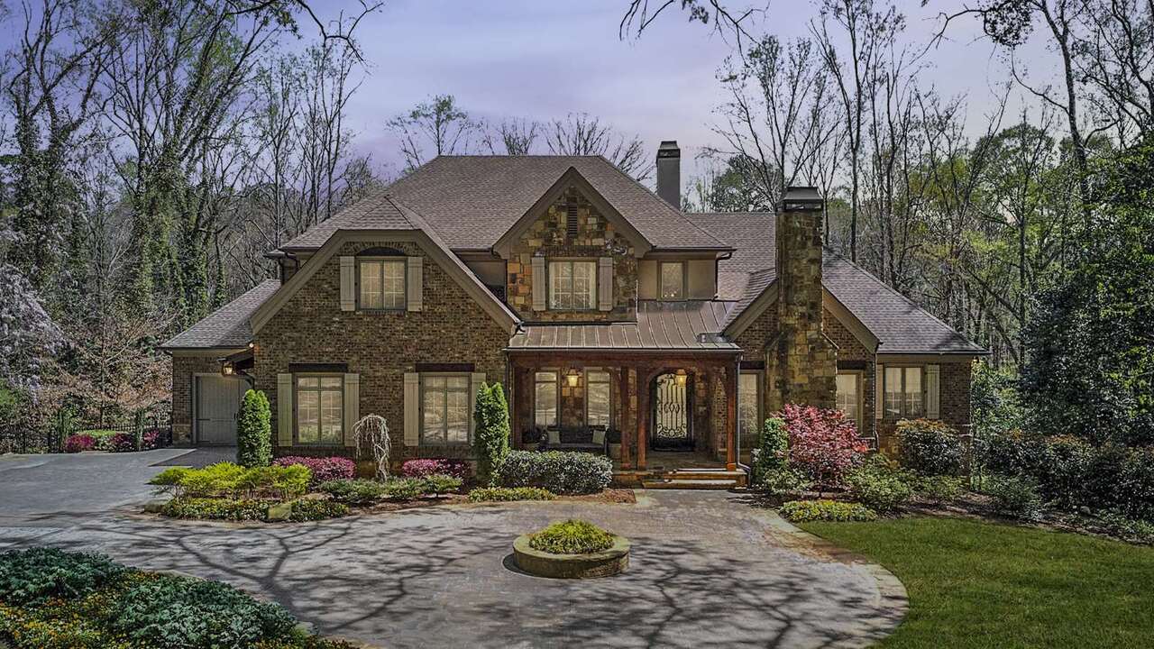Luxury Gated Estate privately tucked away on 1.87 acres! Gas-lit wooden entry gate w/custom welded iron fencing & stone pillars. Covered Entry accented by natural wooden beams; gas lanterns & one of a kind door overlooks stone circular turnaround. Well thought out layout perfectly blends the life of luxury with functionality of everyday living offering 6 Bedrooms & 7.5 Baths w/7392 sq ft. Two story light filled formal entry foyer bracketed by elegant Dining Room & fireside Study. Great Room with custom built-ins opens to the fireside Covered Porch. Chefs Kitchen opento large breakfast room & Vaulted Keeping Room boasts Pro-Grade Stainless Appliances (inc. ILVE Majestic 7 burner gas range w/2 ovens, Subzero dbl. refrigerator/freezer w/custom paneling), oversized island, abundance of custom cabinetry w/under cabinet lighting & catering kitchen plus laundry room. Stunning Master Suite on the main level with separate customized walk-in closets & spa-inspired bathroom featuring zero entry frameless shower with marble. Four Guest Suites on the secondary level with large bedrooms & ensuite baths. DREAM Terrace Level that opens to Covered Terrace Patio & Pool. Finished Terrace is a seamless extension of the home perfect for entertaining! Au-pair/In-Law Suite, Full Workout Room w/padded Flooring, Theater, Sauna, Playroom, Wine Cellar, HUGE Living Room with Full Bar. Lot professionally designed to capture all the elements of modern-day retreat including manicured lawn with architecturally designed landscaping surrounded by untouched land creating a natural buffer of additional privacy. Resort style pool area with slide surrounded by flagstone pool deck & entertaining spaces & sodded portion of the rear ideal for play. AMAZING Retreat within the City!