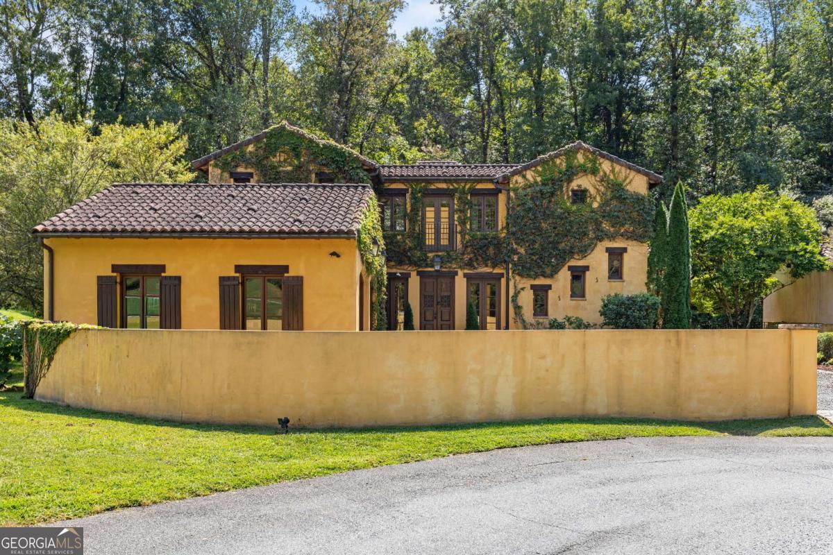 Why buy a vacation home in Italy when you can live the dream in the foothills of the North Georgia Mountains? Tucked within an exclusive enclave of Italian-inspired residences inside the prestigious Montaluce Winery & Estates, this 4-bedroom, 4-bath Tuscan villa is a romantic getaway blending elegance, character, and modern comfort. This exquisite home is true to its culture. Upon arrival your eyes are met with the home painted in the warm, sun-kissed hue of Tuscany. The attention to every detail of the time period is showcased with authentic terracotta roof, a home wrapped in lush climbing ivy-this three-story residence feels as if it was lifted straight from the hills of Umbria. Inside, you'll find gracious gathering spaces highlighted by three fireplaces, a gourmet kitchen with a large island, and seamless flow to expansive terraces and loggias overlooking the vineyards and mountains. Each bedroom offers private retreat and spa-inspired baths, while every detail whispers of timeless charm. The handcrafted detailing radiates sophistication with authentic tile and wood flooring, and eye-catching ceilings with custom beams. Outdoor living is at the heart of this home. A charming courtyard open to the warm sky offers its own fireplace and creates the perfect setting for gatherings, and enjoying your favorite wine from one of two restaurants on site. Montaluce Winery & Restaurant or Trattoria di Montaluce - a more casual Italian dining experience. The enclave of Tuscan homes enjoys a warm community life and amenities. The community offers a lifestyle unlike any other with resort style pool, views of the vineyard, a bocce ball court, and riverside trails to leisurely explore. Whether it's sipping estate wine on the terrace, strolling vineyard paths, or entertaining guests by firelight, this villa delivers the best of European living-without a passport. All within easy accessibility to parks, lakes, mountains, shopping, an hour from Ellijay/Blue Ridge and minutes from historic Dahlonega, yet worlds away from ordinary life. ****Highlights**** This amazing home was built as the Showcase Home, with custom upgrades not found in others at the time. **4 bedrooms, 4 full baths across three levels** **Authentic Tuscan architecture with tile roof, beamed ceilings, and custom millwork** **Three fireplaces, tiled floors and wooden floors** **Hot tub and outdoor kitchen** **Courtyard with outdoor fireplace, terraces with panoramic views** **Located in the prestigious Montaluce Winery & Estates with two on-site restaurants and private event space for entertaining** **Private setting, amazing views** Your Italian villa awaits-closer than you think.