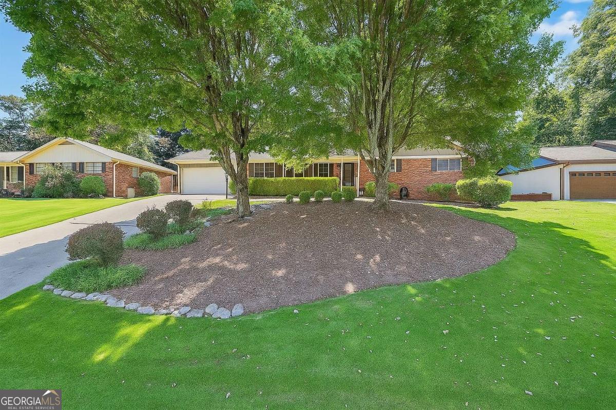 Stroll up to this all-brick Tucker ranch and enjoy a beautiful yard with a front porch made for rocking chairs and checkers (without any logo disputes). TWO living rooms, separate dining room (or office?) and laundry/mud room, two-car garage, AND a back patio with a fenced-in, well-manicured private backyard. Just a short stroll to Brockett Elementary in a perfect neighborhood setting, enjoy being close to the cul de sac. Classic, cozy yet roomy, single-level living...so, no stairs to trip over when you're carrying laundry, groceries, or toddlers with opinions. Location Perks You'll Love: Tucker's brewery, family restaurants, seasonal festivals, nearby Stone Mountain Park, downtown Decatur for shopping and fine dining, AND quick access to Lawrenceville Hwy & Hwy 78. ALL for under $400K!