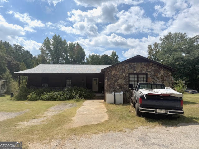 Investment Opportunity-CASH or Conventional Buyers Only!! This home offers 4.26 acres and the road frontage for an potential flat building lot. Calling ALL BUILDERS! Beautiful land in front of this home in the country most part of McDonough. Built in 1987, NEW ROOF-replaced in 2025, stone and wood siding, wood burning fireplace. This home offers 4 bedrooms with potential for 5th bedroom (once renovated). Also offering 3 full baths with potential of 4 baths once the additional bath is finished. Home is currently cooled by window units. HVAC needed during renovation. Barn/carport area for parking cars. Construction trailer located on the property. The trailer has a small kitchen, bathroom and living area. Current tenant may want to rent from the new owners. Backyard is partial wooded. This property is listed "As Is".