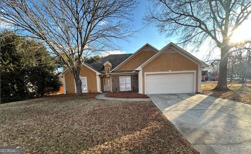 Welcome to 100 Winslow Court in McDonough, GA, a beautifully maintained ranch-style home located in the sought-after Wesley Lake/Moorings subdivision. This charming residence offers comfortable one-level living with a spacious and inviting layout that includes three generously sized bedrooms and two full baths. The primary suite is thoughtfully positioned for privacy and relaxation, featuring ample natural light and an en-suite bath. The open living area is anchored by a cozy fireplace, perfect for gatherings or quiet evenings at home, while the kitchen offers plenty of cabinet space and a functional flow ideal for everyday living. A mix of tile, vinyl, and carpet flooring adds character and comfort throughout the home. Outside, the large, level lot provides a peaceful setting with mature landscaping and room to enjoy the outdoors. Additional highlights include a two-car garage, stucco-and-brick exterior, and a quiet cul-de-sac location just minutes from shopping, dining, I-75, and top local amenities. This home offers the perfect blend of charm, convenience, and community.
