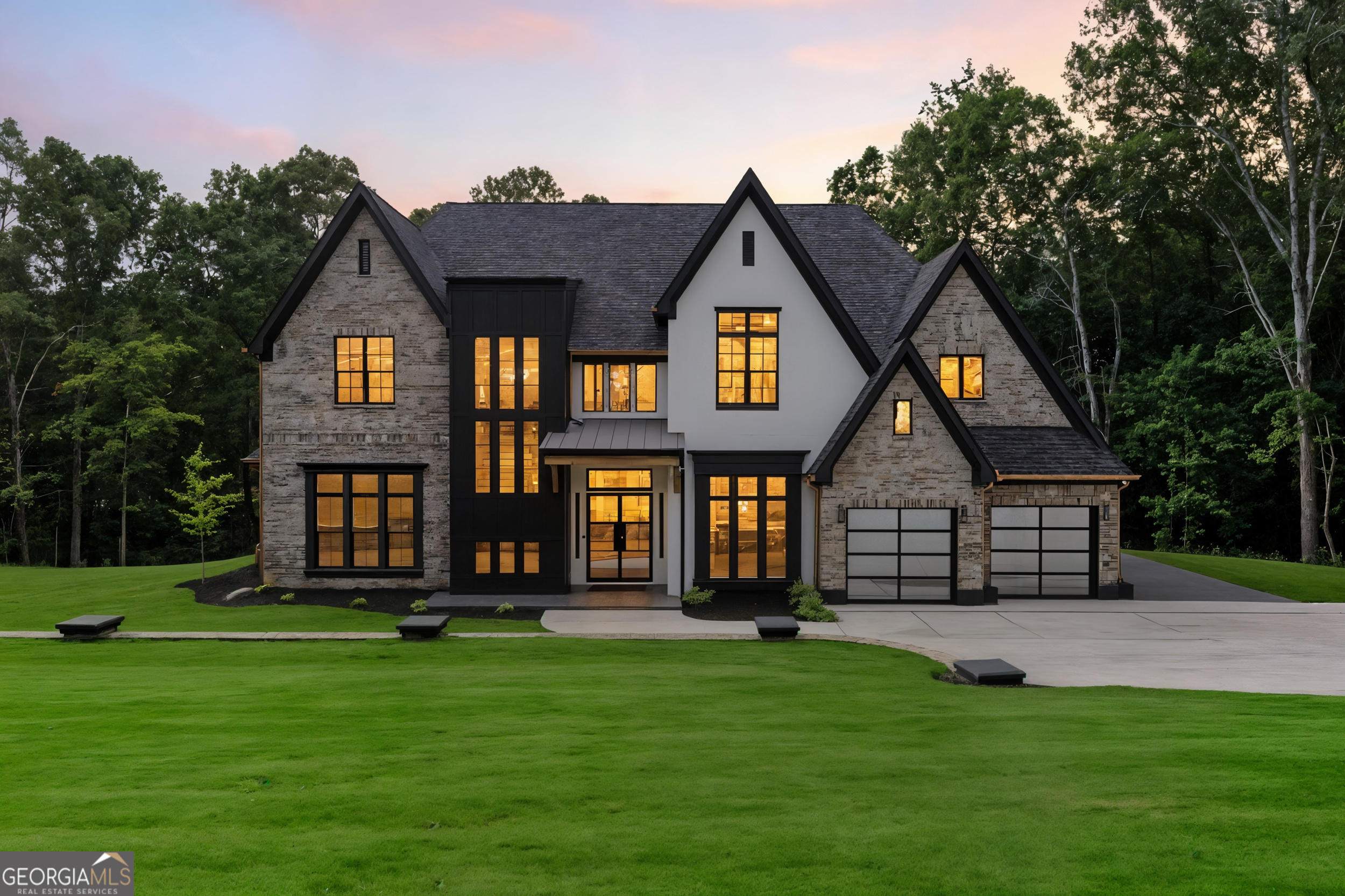 Step into a world where innovation, craftsmanship, and contemporary luxury blend seamlessly to create a home like no other. Nestled behind a private gated entrance situated on a large private lot, this custom-built estate embodies timeless sophistication with modern conveniences designed for effortless living and elegant entertaining. The home commands attention with its rounded matte black and copper gutters, Wi-Fi-enabled LiftMaster gates, and a striking matte black post-capped fence constructed from massive 6x6 railings and bold 8x8 posts-framing the residence in refined strength. The exterior showcases ceramic-coated paint that's not only beautifully smooth but also self-cleaning for enduring beauty with minimal maintenance. Step inside through 8-foot sun-repellent green-tinted windows framed in sleek black vinyl, and be welcomed by soaring ceilings, 12-inch baseboards, and 8-inch casings that echo the home's meticulous detailing. A dramatic 25-foot foyer chandelier sets the tone for what lies ahead. The heart of the home is a designer chef's kitchen, curated for both performance and style. It features granite countertops, a commercial-grade JennAir appliance package with double ovens, a professional cooktop with an infused griddle, a custom 7-foot panel-matching refrigerator, a drawer microwave, and an artistic charcoal-finished vent hood. A fully equipped butler's pantry with wine fridge and built-in cabinetry leads to a walk-in chef's pantry complete with glass door, custom shelving, and cabinetry for large appliances. Formal dining room with coffered ceiling, a 6-foot chandelier, and gallery-style wall inserts Every inch of the home is integrated with smart living features-including Wi-Fi-enabled smoke detectors, smart switches, facial recognition exterior locks, and Wi-Fi lights with built-in speakers in every room for a fully immersive audio-visual experience. The entire home is pre-wired for surround sound, including a media room with motion and sound-censored LED lighting for an unforgettable movie night. The primary suite on the main level is a sanctuary with 16-foot vaulted ceilings, a custom recessed niche with ambient lighting, and a spectacular walk-in closet featuring motion-activated lighting, custom built-ins, and a full-length dressing mirror. The spa-inspired ensuite is a masterpiece: marble-clad walls, a standalone soaking tub, oversized vanities with dedicated makeup station, a walk-in glass shower, and a digital bidet offering heated/cooled water and a remote control. Elegant living room with 16-foot coffered ceilings, gas fireplace with custom stucco mantle, and black built-ins with floating shelves. Bright and airy with triple transom windows and an 8-foot iron glass door. The upper level offers a flex room/rec space, a private home theater with LED and sound-responsive lighting, and three beautifully appointed bedrooms. One suite features floor-to-ceiling honeycomb and dymo wavy tiles, a matte black mirror, and double vanity with Corian counters. Each bedroom includes custom California-style closets for optimal storage and design. Venture out back to a resort-style covered porch, designed for grand entertaining or serene evenings. Tongue-and-groove wood ceilings soaring over 16 feet, brick-accent columns, slate flooring, and motion-activated linear soffit lighting. The outdoor kitchen is finished in matte black leathered granite and equipped with Lion appliances-including a built-in fridge, grill, and sink-while a gas log fireplace with a 15-inch cedar hearth completes the ambiance. Additional features: NO HOA -Three-car tandem garage with additional RV/boat parking pad -8-foot matte black, full-view metal garage doors -Glass staircase railing with matte black accents overlooking the open loft and foyer -400-amp service pre-wired for a future pool -Dedicated office space with serene backyard views-perfect for working from home.