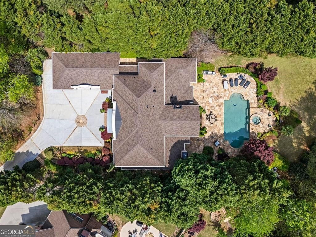 Welcome to an extraordinary six-bedroom, seven full and two half-bathroom masterpiece nestled in the prestigious, gated Northshore section of Windward-perfectly positioned on the renowned Golf Club of Georgia. From the moment you step into the grand two-story foyer with its glittering chandelier, this home radiates elegance and thoughtful craftsmanship. The main level boasts a luxurious primary suite, a paneled executive office, formal living and dining rooms, and a chef's granite gourmet kitchen-one of three full kitchens, including a second prep kitchen nearby and a full kitchen on the terrace level, ideal for entertaining on every scale. Impeccable hardwoods flow throughout the main levels, while travertine tile graces the expansive terrace level, which rivals any private resort. There, you'll find a state-of-the-art home theater, steam room, sauna, fully equipped gym, and an oversized recreation room that opens seamlessly to the resort-style pool and spa with exterior access to it's own private full bath. The outdoor space is just as breathtaking-featuring a large, private, fenced backyard that's perfect for entertaining, relaxing, or hosting unforgettable gatherings. Whether you're enjoying serene mornings overlooking the private pool or unwinding in your private spa oasis, this home delivers unparalleled luxury and lifestyle in one of Alpharetta's most desirable gated communities. The Northshore of Windward has it's own clubhouse, sport court, swimming pool and tennis courts. Windward is a 3,400 acre master planned community that enjoys an award winning environment that has been designed to take full advantage of the private 195 acre Lake Windward. A private membership at Windward Lake Club, with tennis center, pools and marina available. Enjoy kayaking, paddle boarding and so much more on Lake Windward a peaceful lake with electric motor only... This community surrounds The Golf Club of Georgia, a private membership club with two 18-hole championship courses.