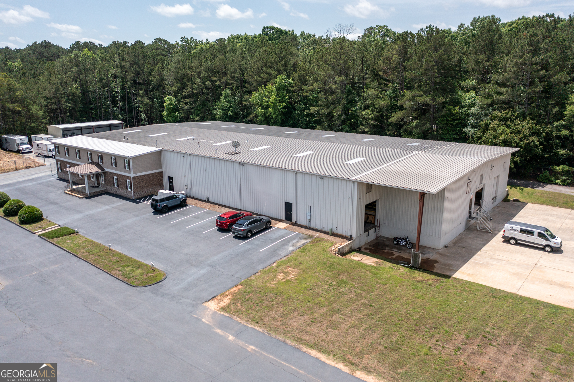 Property Description: Industrial property boasting a 21,464 SF office/warehouse building with a 17-19' clear ceiling height in the warehouse, located in the city of Bogart. This versatile property features five roll-up doors and two fenced areas, providing security and ease of access. The office space provides a professional environment for administrative activities, meetings, and client interactions, while the expansive warehouse area offers ample space for storage, operations, and logistical needs. Multiple roll-up doors ensure efficient loading and unloading, while the fenced area provides added security and privacy. This property also offers over 3.5 acres of undeveloped zoned industrial land. This is an excellent opportunity for businesses seeking a combined office and warehouse space with flexibility, functionality, security, and the ability to expand. Location Description: The property is just 1 mile from GA 316 and 1/10 mile from Atlanta Hwy, offering excellent access to major transportation routes and seamless connectivity to Athens and the surrounding areas. This prime location is ideal for businesses seeking visibility and accessibility in a high-traffic area with direct routes to downtown Athens and beyond.