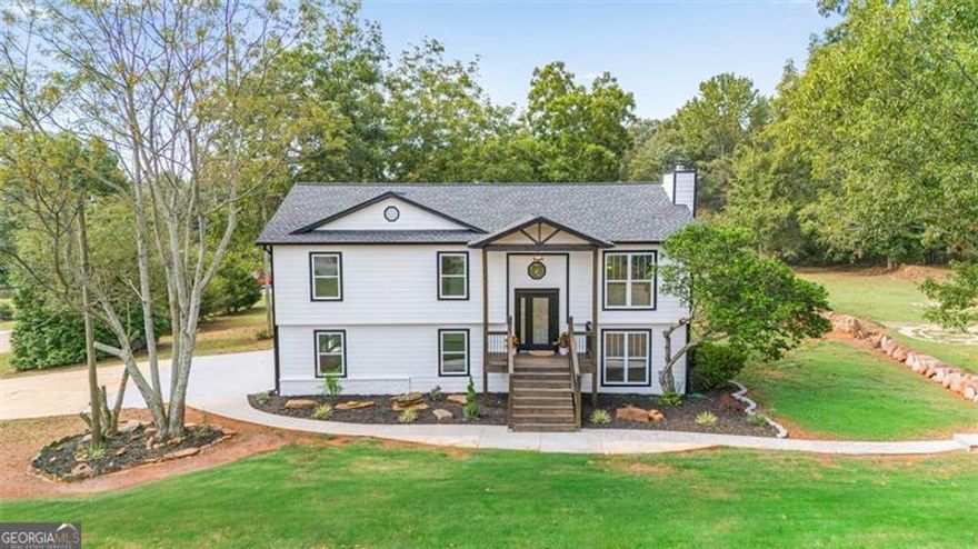 MUST SEE - An Immaculate Modern Renovation on Nearly 2 Acres! Experience the perfect blend of modern luxury and countryside tranquility in this fully renovated home - a true showcase of artistry and craftsmanship. Whether you're looking to establish a homestead, need extra space for vehicles, or simply want your own private retreat where you set the rules, this property delivers. Situated on a level, corner lot with just under 2 acres of cleared land, the home offers two long driveways with access from both roads, making it as functional as it is beautiful. The renovation was comprehensive and thoughtful, including a new septic system, new architectural shingle roof, modern garage doors, oversized back deck, concrete wrap-around walkway, and a grand front porch entrance that immediately sets the tone. Inside, prepare to be inspired. The soaring ceilings, recessed lighting, and sparkling chandelier create a bright and dramatic entrance. The open-concept kitchen, dining, and living area flow seamlessly together, anchored by a striking oversized island. Two-tone cabinetry, dramatic quartz countertops, and statement lighting give the kitchen both elegance and character. The bathrooms are equally impressive - thoughtfully designed with high-end finishes and curated lighting to provide a spa-like experience at home. Every space has been designed to feel both luxurious and welcoming, combining warmth with modern sophistication. This isn't just a renovation - it's a lifestyle upgrade. Come see for yourself why this home is the perfect balance of modern design and country living.