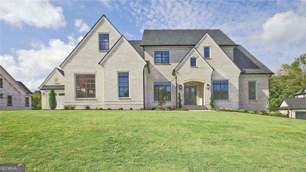 This is an exceptional opportunity in City of Buford Schools and in Hall County! This 4-sided brick estate home combines solid craftsmanship with luxury living on 3 sprawling acres. This new home features everything you could want in a new modern plan - open, inviting and simple living! The beautiful & classic hardwood floors greet you as you step inside. The home is unique as it boasts an oversized owners suite on the main floor featuring a laundry room, spa-like bath with soaking tub, double shower and his and her vanities. The main floor also boasts a study and a formal dining room that seats 12 with a butler's pantry. You could add a beverage chiller and it would be perfect for entertaining! The gourmet kitchen is open to the fireside family room featuring built-ins, coffered ceilings and a breakfast room. The kitchen is a chef's dream with loads of cabinets, countertop space and a working island with a huge walk-in pantry. The state of the art gas stainless-steel appliances will make cooking a true experience. There is a covered porch and grilling deck outside. There is a sizable mud room with lockers that complete the main level. As you go upstairs you will find 3 large secondary suites with walk-in closets and private baths. You can enjoy the upstairs family retreat as a second living area for kids or extended guests. There is also an office, exercise room, recreation room and loads of storage. The terrace level is full of light and awaits your finishing touches. This beautiful home site has a 4-car garage and the backyard has plenty of room for a pool. The estimated completion date is Spring/Summer 2025. The stock photos of this exact floorplan are used in this listing. The basement is shown finished however this basement will be unfinished. The builder can finish the basement for an extra fee. This pricing includes the builder financing the build - if you move to contract prior to December you can do a construction loan and the price will decrease by $150,000. During that time the builder will except changes to the floor plan and finishing materials with a deposit.