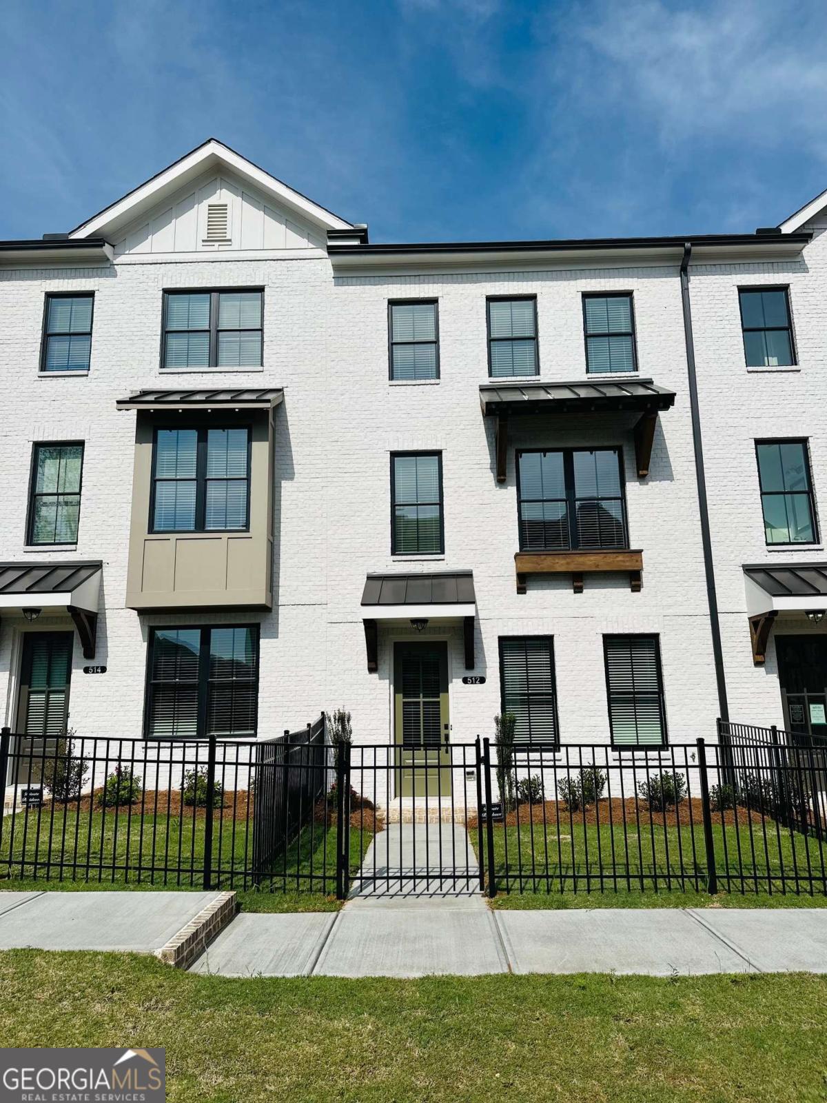 Explore the charm of urban living nestled within the lively Market Square District of Sawnee Village. Located in the heart of Cumming, GA, this community unveils a collection of impeccably designed townhouse tailored to your needs. Conveniently located across from the Cumming Elementary school and Otwell middle school, minutes from City Center and Cumming Library The Glendale Plan spans three levels, offering 3 bedrooms and 3.5 bathroom, 2 car garage and gated front yard. The terrace level welcoming bedroom accompanied by a beautiful ensuite makes an ideal space for guests or a home office. On the main level, open concept family room, dining area, and chef-style kitchen featuring 42" light grey cabinets and quartz countertops. Stainless-steel GE appliances, white backsplash, beautiful hardwood floors and spacious outdoor deck complete this modern yet functional area. The third level welcomes you to a spacious Primary Suite with a walk-in closet and a contemporary double-vanity bathroom, complete with a walk-in shower. Additional bedroom with its private bathroom and walk-in closet and laundry room with washer and dryer included complete this top-level. Half rent for the month of October 2025. Agent owner.