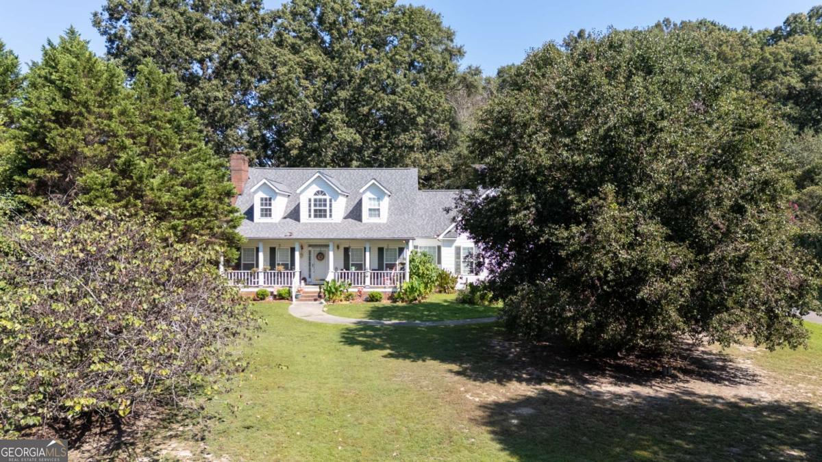 A Country Retreat That Instantly Feels Like Home...From the moment you turn onto the long, tree-lined driveway, you'll feel a sense of peace. The drive itself sets the tone with a beautiful yard, mature trees, and a serene landscape that makes it feel as though you're finally arriving home. As you approach the property, the welcoming rocking-chair front porch invites you to slow down and take in the view. Step inside this one-owner property and discover a layout designed for both comfort and function. The inviting living room, anchored by a cozy gas-log fireplace, creates the perfect gathering space for friends and family. A dedicated dining area flows into the separate kitchen, offering ample storage, workspace, and room for casual meals along with an eat-in kitchen area as well. The primary suite, conveniently located on the main level, features a spacious en suite bathroom for added privacy and comfort. In additional, a half bath, dedicated laundry room and a two-car garage make everyday living easy. Take the charming staircase to the second level, where you'll find two additional bedrooms and another full bathroom. Don't miss the walk-in attic space ideal for storage or seasonal items. Outside, the acreage provides wide open spaces.Simply a private escape from the hustle and bustle of everyday life. With just a little updating, this property could easily transform into a magazine-worthy country estate, blending timeless character with modern comforts. This property truly feels like home the moment you arrive. There is an additional 45+ acres available to be purchased.