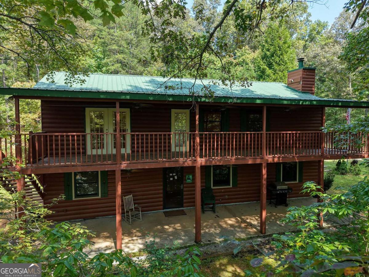 Rustic four-bedroom, two-bath log-sided cabin, nestled in a private, serene setting. This inviting 'fixer-upper' retreat features a charming stone fireplace, hard wood floors, and a dining area perfect for family gatherings. The spacious kitchen boasts stainless steel appliances and a convenient pantry. The expansive master suite opens to a covered deck, ideal for quiet mornings. Enjoy outdoor living with a covered patio/rocking chair porch, and a fire pit for cozy evenings under the stars. The property includes a huge garage/workshop with a wood-burning stove, an office, and ample storage room, blending wilderness elegance with practical functionality. There is also a storage shed and greenhouse in the back. The home has been vacant for a while and waiting for just the right buyer or investor to restore it. A Hold Harmless form (see documents) must be signed and returned to LA prior to entering the property.