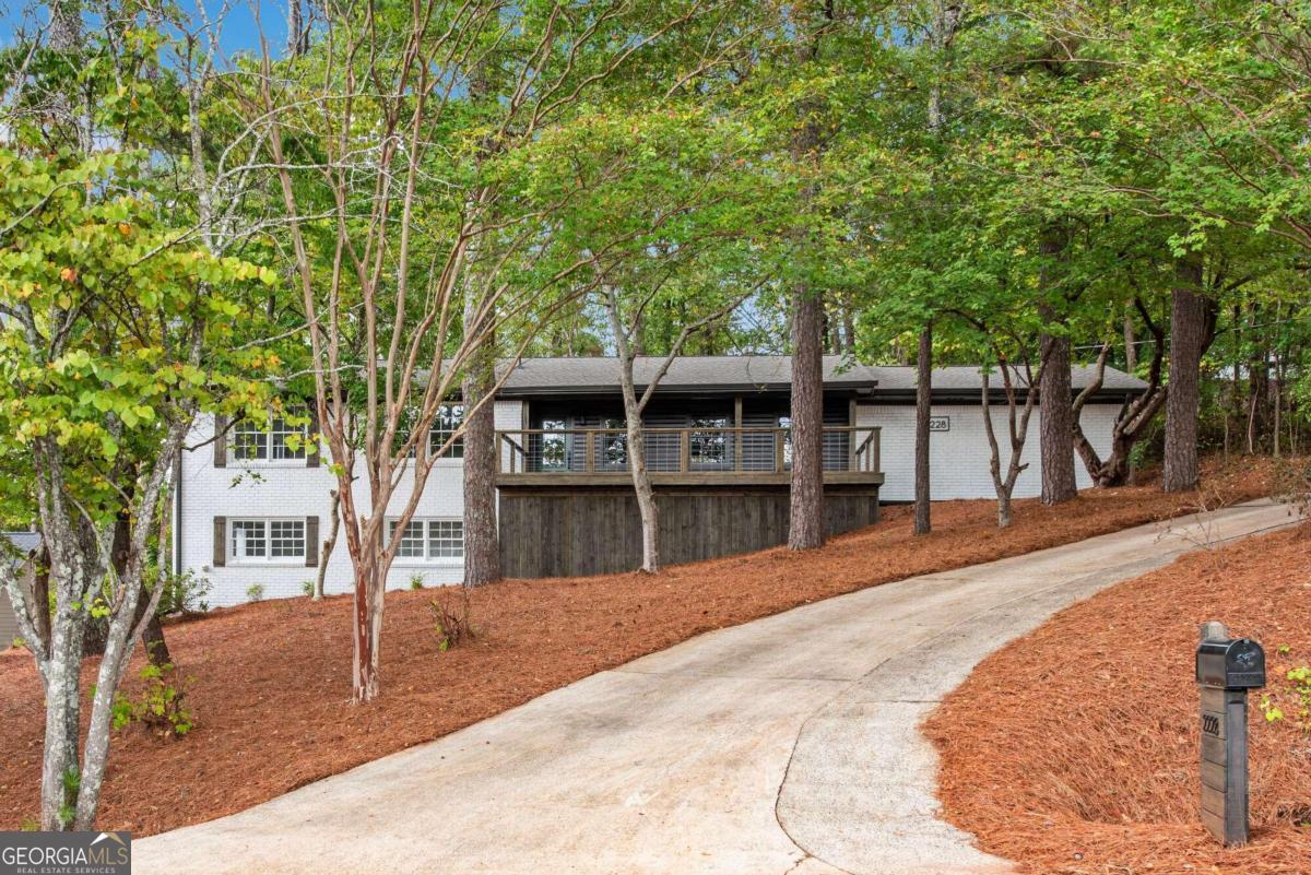 Stunning ranch retreat in prime West Cobb location overlooking the entrance of Ellis subdivision! Discover this exquisite ranch home perfectly situated on a private, low-maintenance lot in the sought-after area. Home has a finished basement and a spacious 2-car garage, this residence exudes the charm of new construction, crafted by an experienced builder. As you approach, you'll be captivated by the charming curb appeal that includes a generous front porch deck, wood columns, stylish lantern lighting, and freshly painted dark urbane bronze siding complemented by new shutters and gutters. The inviting new front door sets the tone for the beauty. Step inside to be greeted by views of the open-concept living space that seamlessly connects the living room, dining area, and kitchen. The urbane bronze accents flow through the interior, highlighting features such as the brick fireplace and the matching kitchen island. Every detail has been meticulously attended to, with all-new interior shaker craftsman doors, knobs, and hardware. The kitchen features new white shaker cabinets, SS appliances, black hardware, a custom wood shiplap vent hood, floating shelves, a built-in microwave, chic subway-tiled backsplash, quartz countertops, a ceramic farm sink, and a kitchen island with overhang for bar seating. A separate laundry room off the kitchen offers added convenience, along with easy access to the garage making bringing in groceries a breeze! Natural light floods the home, accentuating the shiplap-covered walls, custom light fixtures, and rich stained oak hardwood floors. The exterior glass door off the kitchen opens to a delightful back deck, ideal for entertaining or enjoying a summer barbecue in the low-maintenance backyard, which also has easy access to the driveway. Down the main hallway, you'll find a spacious primary suite featuring a walk-in closet and a luxurious bathroom equipped with a double vanity, private water closet, and beautifully tiled shower with glass door. A secondary bedroom and a spacious full hall bathroom are also located on main, offering convenient guest access. Venture downstairs to the finished terrace level, which includes an additional living room with an exterior door leading to a backyard patio. This level features a 3rd bedroom with a substantial walk-in closet and an ensuite bathroom complete with a double vanity & a tiled tub/shower combo. A potential 4th bedroom offers endless possibilities - envision it as an office, playroom, movie room, or man cave. Additionally, a large finished storage room caters to all your organizational needs. This remarkable home comes equipped with a new HVAC system, a new roof, custom sleek metal staircase railings, and a new water heater, ensuring peace of mind for years to come. No detail has been overlooked in this residence, making it feel brand new. Don't miss the opportunity to call this exceptional property your home!