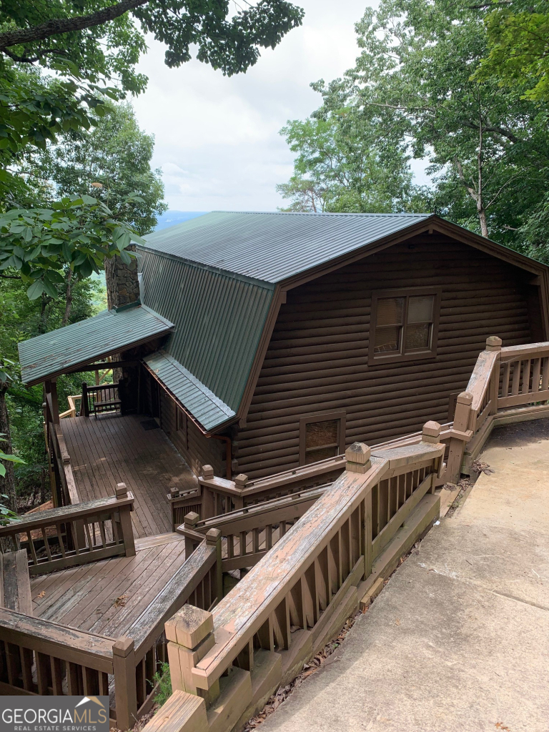 Beautiful Log Home nestled mountainside with gorgeous views of the valley and mountains. Located in a secure gated community this 3,200 sqft home has 4BR and 3BA and features two large exterior decks, two screened in porches, two living areas and a game room. Home was renovated in 2022 adding 1,000 sqft with bedroom, living room, full bathroom and private deck. New HVAC, Water Heater, Exterior Paint and 2 New Decks were completed in 2022. The main floor features all original wood construction with 2 Bedrooms and 1 full Bathroom. The main floor is a full open concept with wood burning fireplace & sliding doors to access the main deck and views. Kitchen is equipped with all SS appliances. The main floor exterior deck offers picturesque views high above the trees (Autumn colors are awesome!). The morning and evening views are amazing and often include wild deer and turkey walking by, and the occasional bear! The main floor also includes a screened in porch with 4-person dining table and washer dryer closet. The Primary Bedroom is located in the upstairs loft and includes a large private Bathroom with dual sinks, shower, and a large soaker tub w/walk in closet. The primary floor also has a seating area w/large windows showcasing the view and separate screened in porch. The downstairs finished area includes a bedroom, full bath, living area and exterior access to a deck with private wooded view. Lower deck was built to accommodate a hot tub and is wired for one.