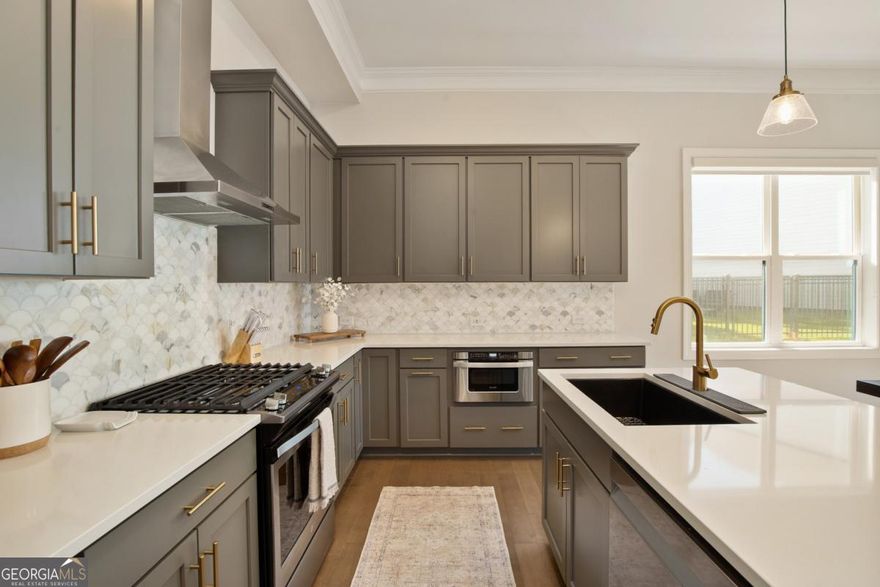 Welcome home. Get ready to fall in love with this beautifully customized end-unit townhome like no other in the community. Located just one mile from downtown Woodstock. This 3-bedroom, 2.5-bath home combines comfort, style, and convenience in one of the area's most sought-after communities with amenities galore. The main level offers an open spacious living room that flows through magnificent sliding doors into your entertaining patio-perfect for seamless indoor-outdoor living. The kitchen features upgraded finishes and an oversized pantry that is a must see. New sink and fixture and a soaring skylight that bathes the kitchen in natural sunlight. Not to mention all the sun pouring in from the added windows being on an end unit. Sleek modern design complete with a fireplace to keep you cozy. As you continue to the upper level you will notice the railings extend all the way up and around the hallway. Upstairs features three bedrooms and a laundry room with custom shelving. The large primary suite offers a spacious tailored closet and a luxurious bathroom with expansive shower and double vanities. Hardwood floors extend through the hallway, which includes a versatile flex space at the top of the stairs, perfect for an office workspace. The extended 2 car garage offers plenty of room for storage and can easily accommodate 2 large SUV's or truck. The home is conveniently located across from guest parking. With thoughtful upgrades throughout and quick access to all that downtown Woodstock has to offer-shops, dining, and entertainment-this home blends modern living with everyday practicality.