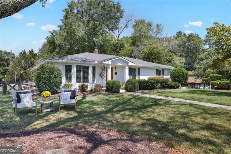 Rare Downtown Woodstock GEM! If you've ever strolled through the heart of Woodstock, you know this home! Perfectly situated on a corner lot just steps from Adair Park and vibrant Downtown Woodstock, this 1954 charmer has been fully renovated while keeping its character intact. Sitting on nearly half an acre with no HOA, this spacious 3,300 sq. ft. home offers 4 bedrooms and 3 bathrooms, including a master suite on the main level. The bright, open-concept main floor boasts modern finishes and thoughtful details that make it both stylish and welcoming. The finished basement is a game-changer - featuring a bedroom, full bath, kitchenette, bonus space, and generous storage, making it perfect for guests, in-laws, or even an income opportunity. Enjoy the spacious lot with a large deck and plenty of parking, all within walking distance to Woodstock's boutique shops, local dining, parks, and year-round events. Don't miss this rare opportunity to own a piece of Downtown Woodstock living! Showings begin on 9/12/2025.