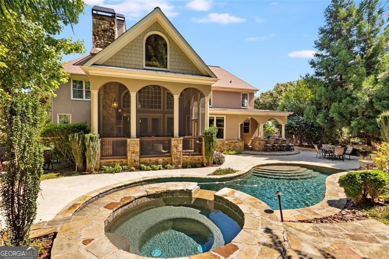 Welcome home to this breathtaking, extraordinary 6-bedroom, 5-bathroom custom home located in the highly desirable "The Falls at Autry Mill" community. You will be blown away by this property where it is just as beautiful on the inside as it is on the outside. The home is privately nestled on a stunning lot that exudes a resort-like feel with an expansive saltwater pool complete with soothing spa and waterfall which offers the perfect setting to unwind after a long day or wind up as you entertain friends and family. The entrance to this home greets you with a grand 2-story foyer filled with an abundance of natural light and upgrades galore like custom arched doorways and large windows, tray ceilings & more. On the main level you'll also find an executive home office with floor-to-ceiling windows and an elegant oversized dining room- perfect for celebrating with family and friends. The 2 story great room with stone floor-to-ceiling fireplace is a showstopper with built-in bookshelf and views of both your incredible backyard and kitchen. Luxurious chef's kitchen with rich wood cabinetry, stone counters, oversized island with sink and seating, high end Stainless Steels appliances, and tons of cabinet storage are a chef's dream! Oversized master suite with private fireplace and sitting room and spacious his and her closets. Crisp & clean upscale master bathroom with huge double vanities, separate shower and soaking tub! All of the bedrooms are extremely spacious. Entertaining at its finest on the terrace level with a magnificent custom bar, entertainment area and game area, gym space and more. Terrace level also perfectly allows for an in-law, nanny or guest suite with an additional bedroom and full bathroom. Stepping outside is an entertainers dream with absolutely incredible outdoor kitchen with built-in grill stations & wine fridge with pool views and private fire pit! Screened in porch with stunning floor to ceiling stone fireplace, arched windows and custom lighting is the PERFECT place for coffee in the mornings and wine in the evenings. To top it all off, The Falls of Autry Mill is a premier neighborhood in Johns Creek with fabulous amenities, 12 tennis courts, 3 pools, a playground, renovated clubhouse, exercise facility, a lake for fishing and access to top notch schools. This home has it all- all that is missing is you! Schedule a tour to see for yourself. This home is a dream!
