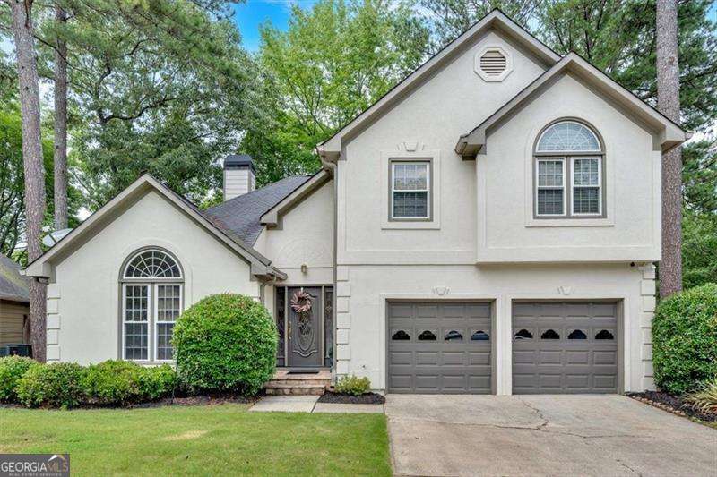 This meticulously maintained home is loaded with high-end upgrades and thoughtful details throughout. The chef's kitchen features granite countertops, a designer backsplash, an upgraded vent hood, stainless steel appliances, and a charming box bay window overlooking the private backyard. Enjoy stylish tile flooring in the kitchen and rich hardwood floors throughout. The spacious living and dining rooms boast vaulted ceilings and a cozy double-sided gas fireplace, perfect for entertaining or relaxing evenings at home. Step outside to the covered deck - an ideal space to unwind while enjoying peaceful views of the private backyard. Generously sized bedrooms offer comfort and flexibility, while the updated owner's suite includes a spa-like bath with a soaking tub, separate shower, and double vanities. Located just a short walk from grocery stores, retail shops, and restaurants, and minutes from The Avenue West Cobb, this home offers convenience and charm in one exceptional package. Don't miss this opportunity to make it yours!