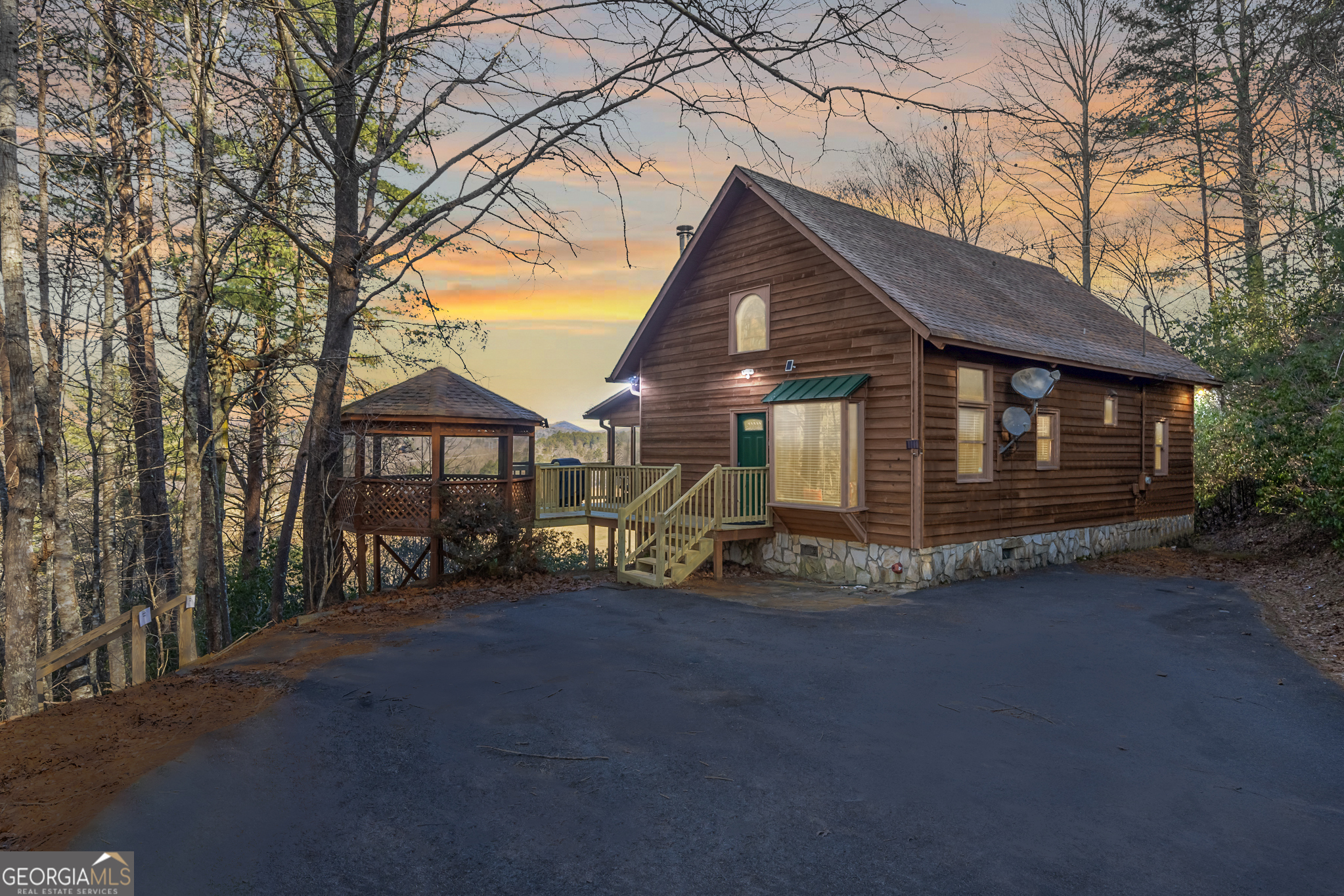 River Frontage! Mountain Views! Acreage! This rustic cabin will check all the boxes on your mountain home wishlist. Be wowed with 316 feet of Toccoa River frontage plus picturesque 180 degree long range mountain and pasture views. Take the long, gated driveway to this very private location that is only 5 minutes to Downtown Blue Ridge. This 3 bedroom with loft, 2.5 bath cabin on over 3 acres has only had 2 owners! Featuring an open floor plan with vaulted ceilings, rustic wood finishes, and charm and character throughout, including 100+ year old stained glass windows repurposed from the original owner's family's church. The open kitchen has granite countertops and stainless steel appliances, along with dining space with a built-in window seat. French doors lead out to a screened-in porch spanning the back of the home for the perfect spot to indulge in the mountain, river, and pasture views. Two spacious bedrooms, one with attached half bath, along with a full bath, and laundry space finish the first floor. Up the stairs is a large bedroom with vaulted ceilings, en-suite bath, and windows to enjoy the views. There is also a loft space perfect for additional sleeping space, office, or however you wish to use it. Enjoy the outdoors with the screened porch that leads to an open deck ideal for grilling, along with a giant gazebo, where you can enjoying a drink while you breathe in the mountain air and enjoy the sounds of the river. Cabin comes furnished to use for your personal mountain oasis or keep as a vacation rental. Make this riverfront, mountain view, rustic home yours today! Very minimal restrictions.
