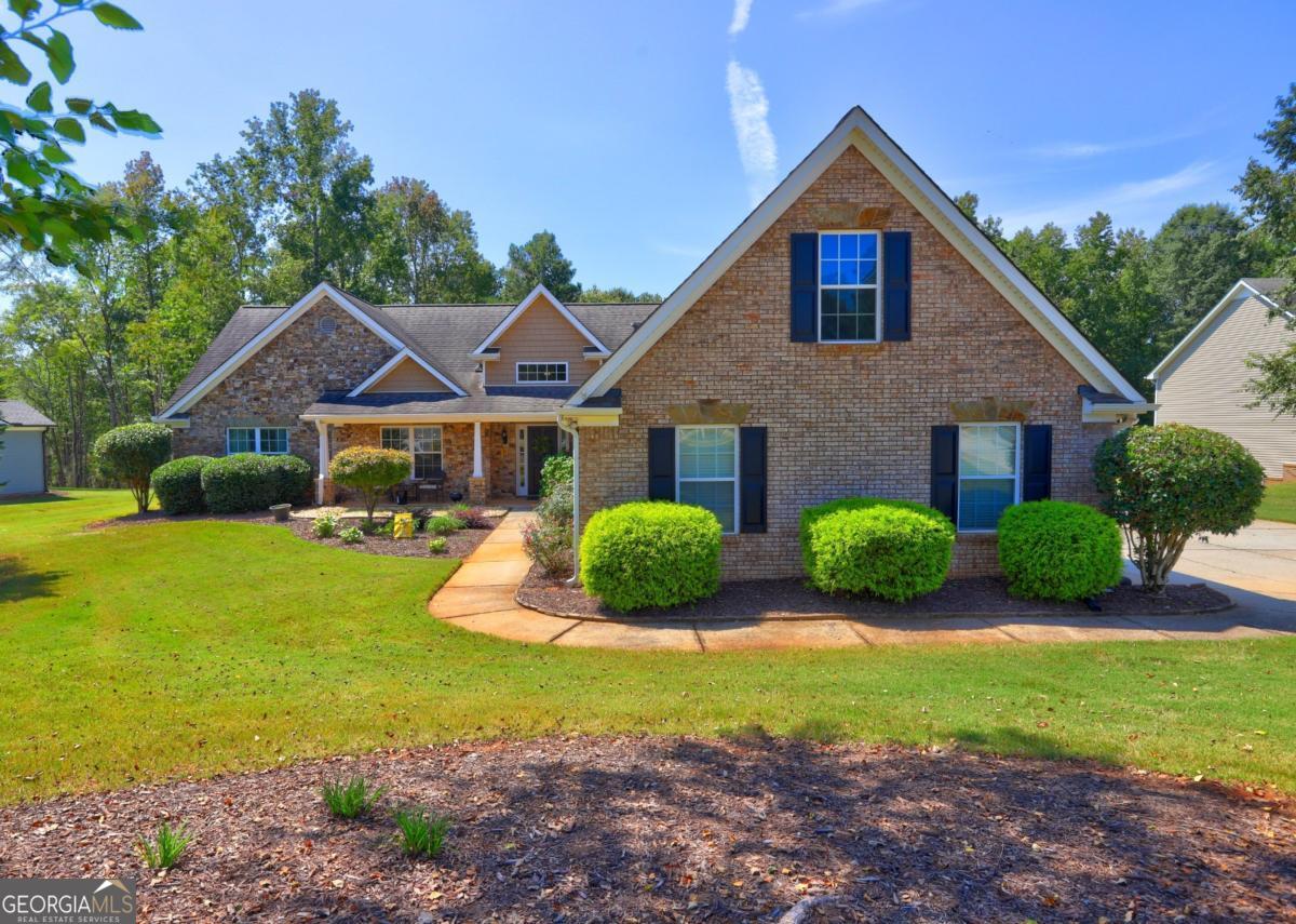 Welcome to this charming ranch home nestled on a spacious 1.03-acre lot in the desirable Gratis area. Featuring a beautiful brick and stone front, this home boasts a large great room complete with a cozy rock fireplace, perfect for gatherings. The open kitchen offers an abundance of cabinets, making it a chefs dream. With a split bedroom floor plan and a versatile bonus room on the main level, you'll have the flexibility for an office, extra den, or nursery. Updated LVP flooring throughout ensures a modern touch, making this home truly move-in ready. Enjoy the serene outdoors from the screened porch that overlooks a large backyard, complete with a workshop for all your projects. Don't miss the opportunity to make this lovely property your own!