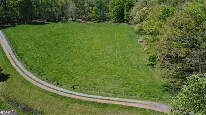 This is Tract 1 on the survey. Private, peaceful, and ready for your dream home! Discover the perfect blend of natural beauty and convenience with this exceptional parcel of land. Tucked away in a quiet, private setting, the property features a beautiful mix of mature hardwoods-no pine in sight-and gently rolling terrain that makes building a breeze. This beautiful parcel offers the ideal backdrop for an estate-style home, gentleman's farm, or multi-generational family compound. Whatever you're envisioning, you'll find multiple ideal home sites scattered throughout the open meadows and shaded woodlands. A long, private gravel driveway is already in place and shared with just two other parcels, adding to the secluded feel without sacrificing accessibility. Public water is available, and the location is hard to beat-just minutes from Canton and Jasper, with easy access to major roads and only about 45 minutes to Atlanta. This is a rare opportunity to own a piece of serene North Georgia land with all the right elements in place.