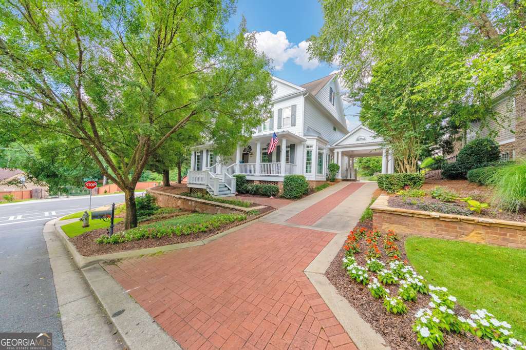 Welcome to this stunning 5 bedroom, 5.5 bathroom home in the Hazelhurst Ridge community in East Cobb! This beautifully maintained residence is filled with designer touches, featuring hardwood floors on the main and upper levels, crown molding, recessed lighting, and thoughtful upgrades throughout. A charming covered front porch leads you into a spacious foyer flanked by a formal dining room and an office with French doors. The fireside family room with built-in bookshelves flows effortlessly to the updated kitchen, complete with stone countertops, a center island with seating, and a sunny breakfast room. The main level also offers a convenient laundry room with a sink and a half bathroom. Upstairs, the oversized primary suite impresses with tray ceilings, a spa-like ensuite bathroom with double vanities, a soaking tub, a glass-enclosed shower, and a large walk-in closet with built-ins. Two generously sized secondary bedrooms each feature their own private ensuite bathrooms. The finished basement offers incredible additional living space with a large media room with a fireplace, a bonus room, a bedroom, and a full bathroom. A detached 3-car garage includes a private bedroom or flex space with its own full bathroom above - perfect for guests, an office, or studio. Enjoy multiple outdoor living areas including a covered side deck, a terrace-level patio, and a rear patio with an outdoor fireplace overlooking the massive fenced-in backyard. Ideally located just around the corner from Lassiter High School and minutes from shopping, dining, and major roadways - this home truly has it all!