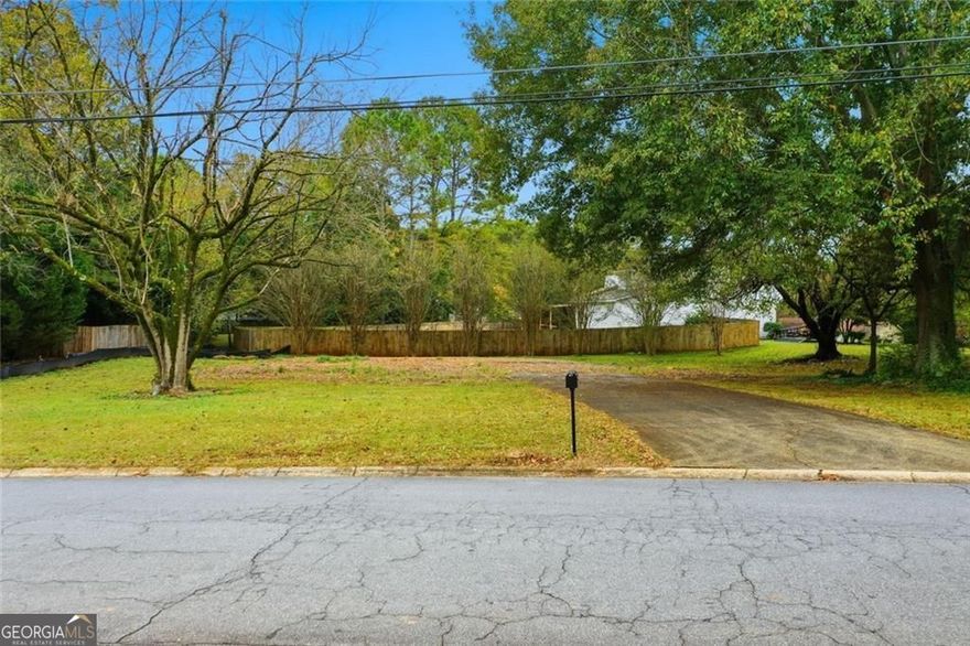 Located in a sought-after East Cobb location, this level, corner lot offers a rare chance to build something truly yours in the Kell High School district. Already cleared and prepped, the lot includes a poured concrete driveway and capped water and sewer lines - a huge head start that saves time and money.  With R-20 zoning in place, the property is ideally suited for a single-family slab home, offering flexibility and convenience for your build. The corner location adds extra curb appeal and access, and the flat terrain means less prep work and more budget for the things that matter inside the home.  No HOA. No teardown. Just a clean slate in a well-established community, minutes from shopping, restaurants, parks, and commuter routes. Bring your vision, your builder, and your dreams. This one's ready to go.