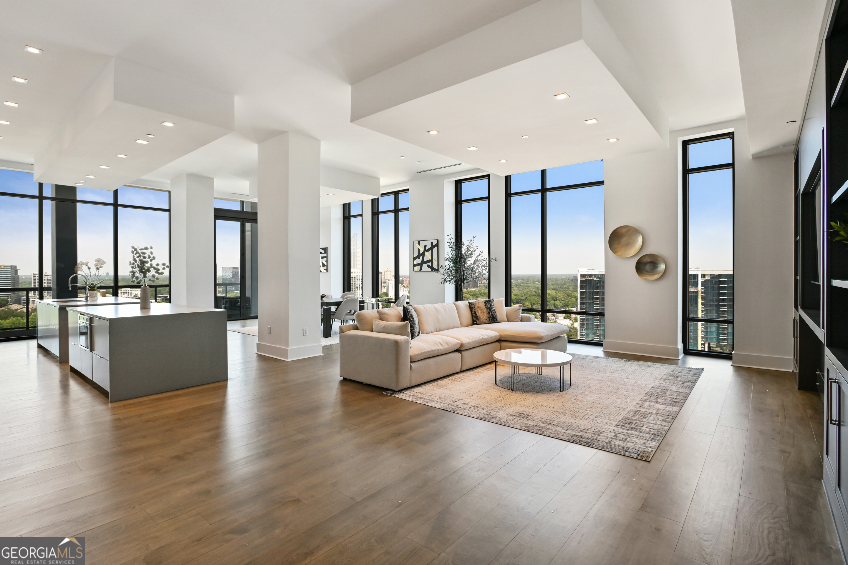 Welcome to a luxurious urban oasis in the heart of Atlanta at 3107 Peachtree Road Northeast, Unit 2003. This modern and elegant residence spans an impressive 4,527 square feet, offering four spacious bedrooms and three and a half beautifully appointed bathrooms. This condominium is a masterpiece of design and comfort, featuring three expansive terraces, complete with a grill perfect for alfresco dining and entertaining. Connect with nature while enjoying the pristine views of Buckhead, each terrace includes a hose bib to care for greenery. The state-of-the-art kitchen is a culinary enthusiast's dream, boasting Gaggenau European appliances, two expansive kitchen islands, a wine refrigerator and a chic coffee bar. Experience the ultimate in relaxation with heated floor bathrooms from your Victoria Albert tub or steam shower. The residence's sophisticated amenities extend to include a private theatre room, a custom built glass-encased home office, and ample space for a home gym. Hardwood floors with built-in floor wash lights add a touch of elegance throughout, while an in-unit laundry room and assigned parking ensure everyday convenience. Residents benefit from a suite of luxurious building amenities including next-level security, a doorman, garage, gym, and a pristine pool. Pet owners will especially enjoy the dog walk area & dog washing station. Discover an unparalleled living experience in this exquisite Atlanta condo, where modern luxury meets timeless elegance.