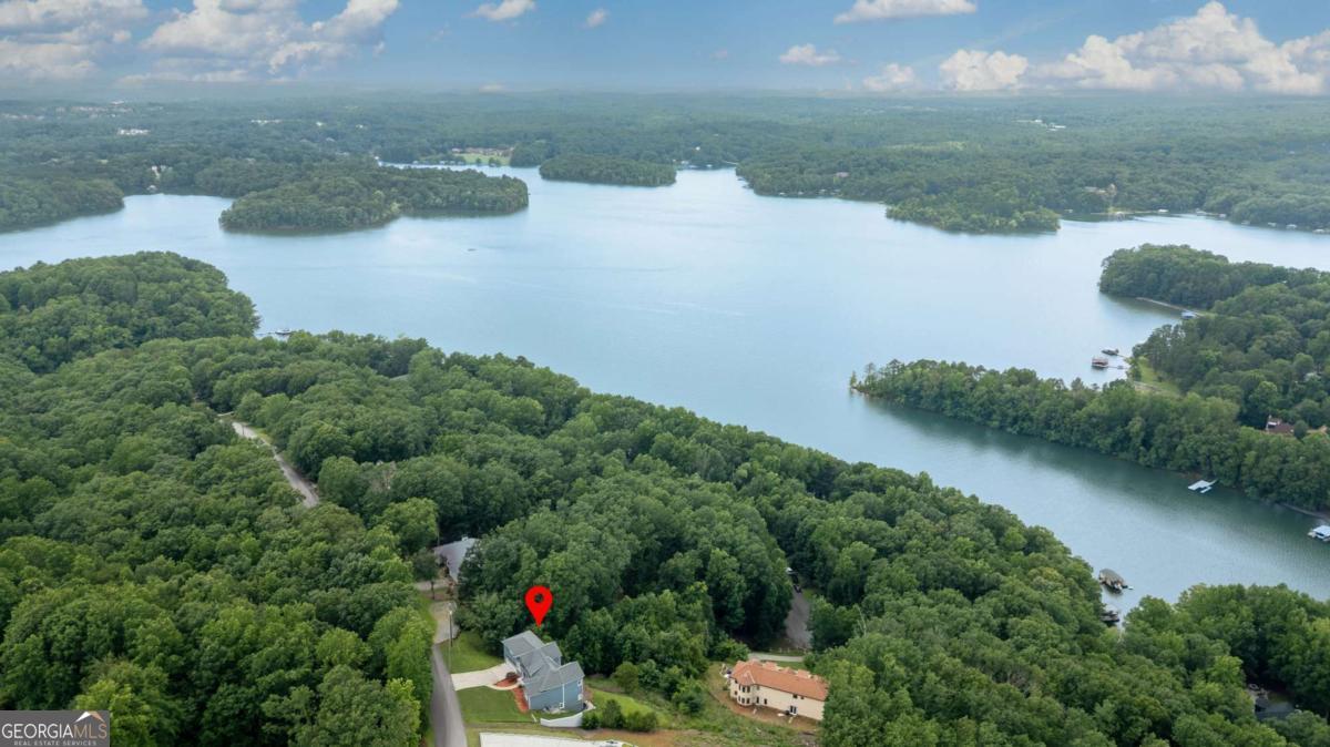 STUNNING LAKE LANIER & MOUNTAIN VIEWS from every level and nearly every room of this energy-efficient home! The photos truly don't do it justice. Enjoy breathtaking views just minutes from all that Gainesville has to offer. You'll be wowed the moment you step inside by the beautiful hardwood floors, soaring ceilings, and abundant natural light pouring through oversized windows. The main level features the primary suite, while a few steps up you'll find a spacious bonus room currently used as a media room-perfect for a guest suite, office, or additional bedroom. The lower level offers two bedrooms, a full bath, a massive family room, and access to an expansive lower deck-all with amazing views. The daylight basement below is unfinished and ready for your expansion dreams, complete with high ceilings and tons of potential. Host gatherings and parties that will wow your friends with stunning lake & mountain views, and enjoy being just 2.7 miles from Little Hall Park for easy lake access. This home is the perfect blend of peaceful privacy and convenience-plus views you simply won't find in Gainesville!