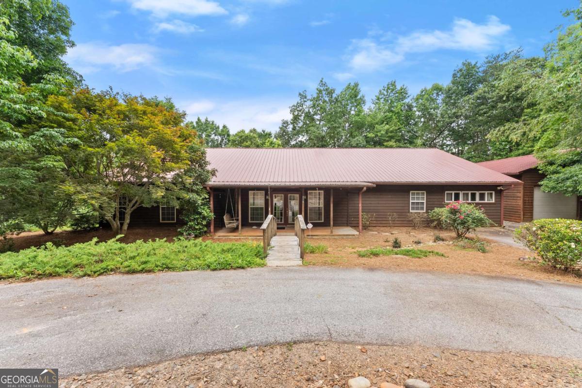 This mountain retreat home is located within the vacation rental approved area of Cleveland, Ga. Upon entry, you are stepping into a large family entertainment space with the wet bar to your left, the kitchen straight ahead, and the carpeted family sofa area to your right. The entry floor is dark stained concrete with a glaze finish. The walls and ceilings are a golden knotty pine throughout. All 3 bedrooms have their very own on-suite and walk-in closet. There are multiple bonus spaces along with a large laundry room. The attic is the length of the house, clean, contains 2 attic fans, and is perfect for storage. The roof, 2 AC units, well pump, 3 zone system, and alarm system are all less than 2 years old. Outside is a garden area, separate fenced-in area, large deck with a hot tub, and privacy. Finally, there is a 1500sqft heated and cooled workshop that has storage, office space, and another .5 bath! Vacation rental, 2nd home, or your daily retreat, it's all possible here.