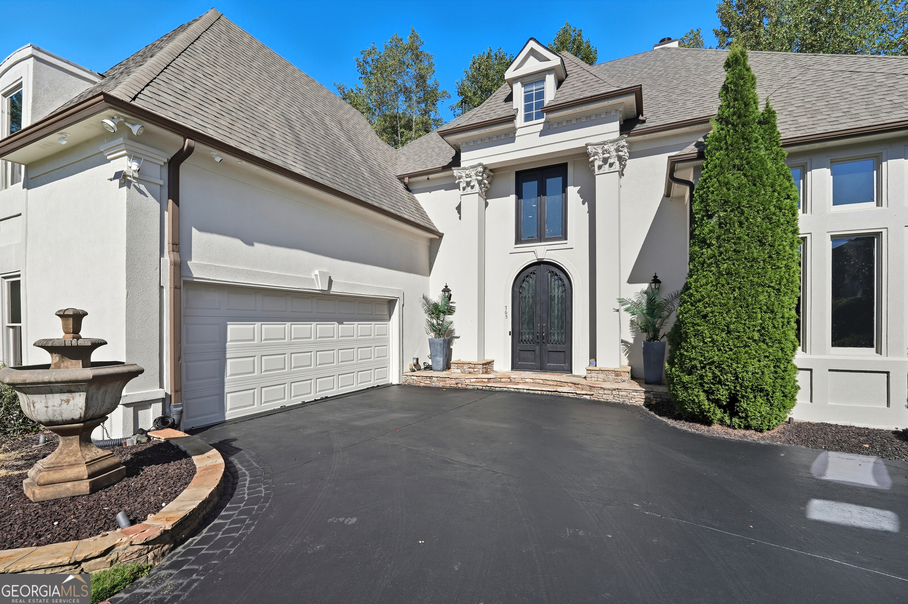 Luxury hard coat stucco home featuring a primary suite on main and exceptional designer updates throughout. Impressive curb appeal with custom iron front door, fresh exterior paint, and hardwood floors. Light-filled interior with 10'+ ceilings, spacious great room, and banquet-sized dining room. Updated kitchen opens to keeping room and leads to deck with stacked-stone outdoor cooking station. Terrace level offers a custom home theater with 3-tier stadium seating, surround sound, popcorn station, and hidden bar behind mechanical screen, plus flex space for gym or recreation. Private putting green and ample storage. Conveniently located near top-rated schools, Avalon, Downtown Alpharetta, and GA 400. A must-see home blending luxury, comfort, and timeless design! * 1% Interest Rate Buy Down for Year 1 with Preferred Lender!