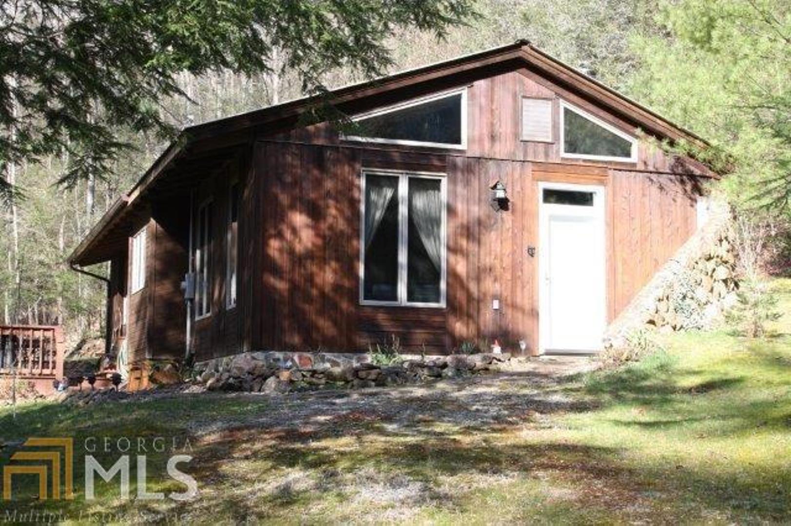 Don t dismiss this one as too small! This 1,000+ square foot mountain situated on 3 acres of beautiful CREEKFRONT property is a darling showplace! Huge double paned casement windows span the entire front of the home inviting the sound of the waterfalls that flows through the property. Bright & cheery kitchen, tons of updated renovations, exposed wooded beams, lg open great room w/wood burning stove, easy one-level living & extremely energy efficient. A perfect couples, small family, or retired couple get-away. This serene community has protective deed restrictions, all paved roads except for last few minutes on private road. Easy drive to Springer Mtn, Aska Rd & just 20 mins from Ellijay.