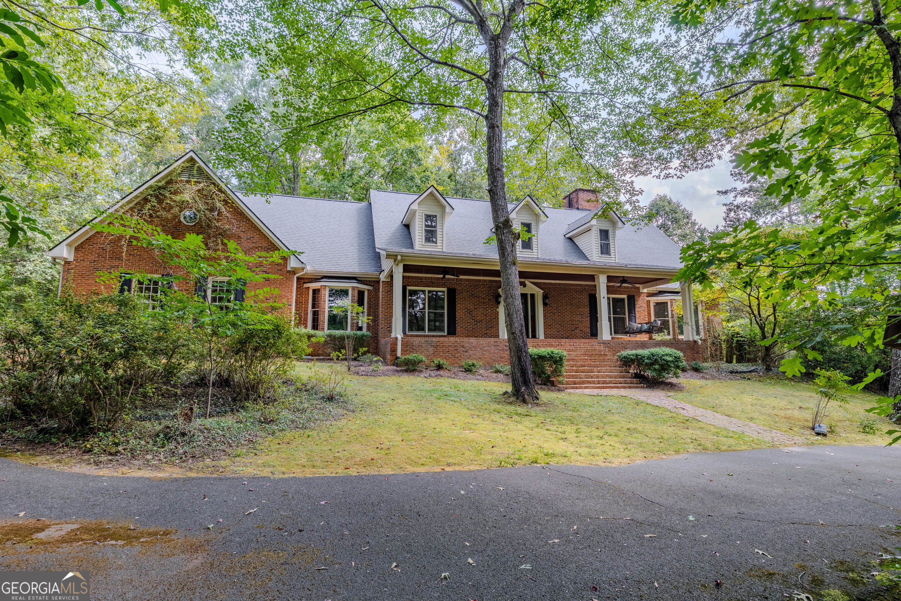 Beautiful brick home with rocking chair front porch down Horseleg Creek Road on over an acre of beautiful hardwoods!! This is a custom built home with large rooms, soaring ceilings and special finishes throughout. The large master on the main has its own brick gas-log fireplace with custom mantel. Master bath has a separate tub and shower and walk in closet. Extra large Great room with custom fireplace mantel and gas logs. Off the great room is a beautifully beamed sunroom with a dedicated heat and air unit great for reading or taking in the beautifully wooded backyard. The open kitchen has a beautiful sitting room or large breakfast area with room for entertaining. Off the kitchen is a great sized mud room/laundry room with an entrance off the back deck for the kids and big kids too. Upstairs you have three more large bedrooms and a nice size bathroom. In the basement you've got flex space with room to finish into play rooms or keep as a workshop. This space is already heated and cooled by a dedicated hvac unit. The basement has its own driveway for teen entry or future in-law entrance and a boat door! The home is 2x6 construction which is stronger and insulated with R-19 in the walls which is more efficient. The parking pad and circular drive make it easy for guests to have access to parking and ingress/egress.