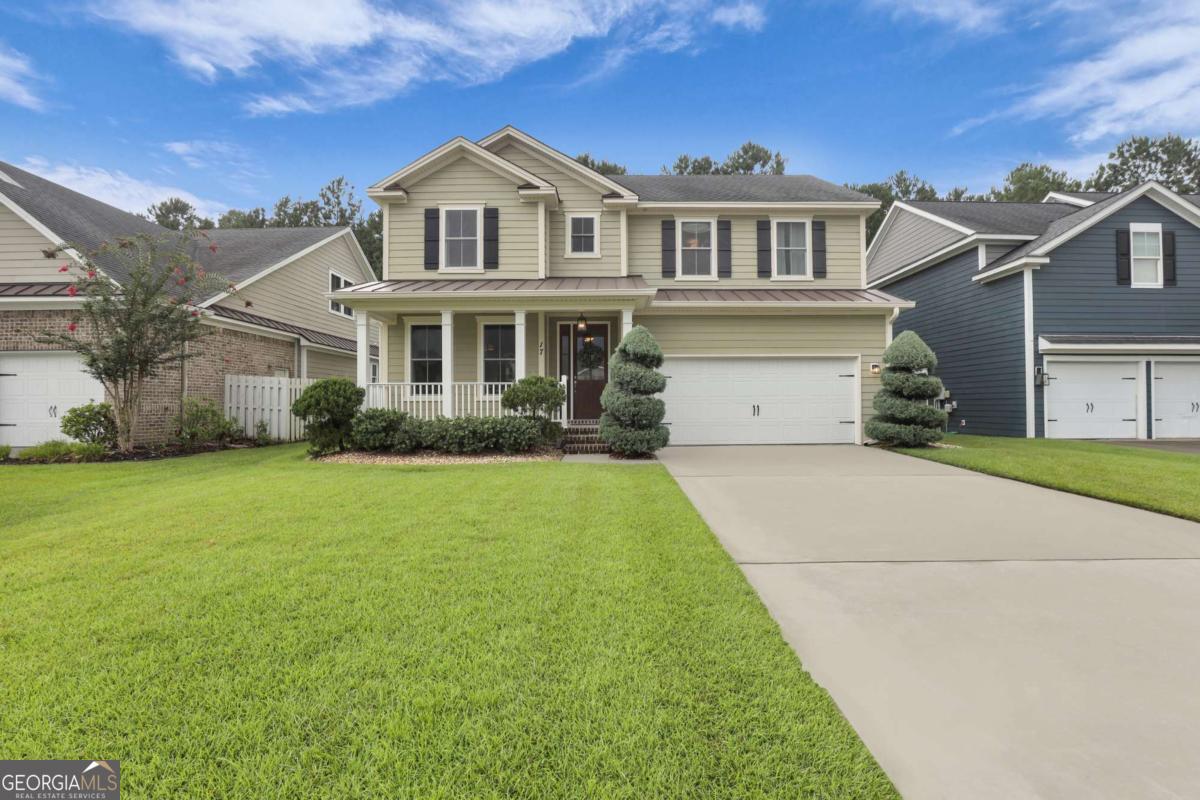 Experience refined Lowcountry living in this 5-bedroom, 2.5-bath residence located in The Enclave-Savannah's premier boutique gated community. From the manicured front lawn with sculpted evergreens and native plantings to the serene, tree-lined backdrop that will never be developed, this home offers beauty comfort, and a connection to nature. A grand two-story foyer welcomes you into a carpet-free home where easy-care flooring flows throughout. The primary suite, located on the main level, offers a luxurious retreat with a spacious walk-in closet, while four additional upstairs bedrooms-each with their own walk-in closet-provide comfort and versatility for guests, family, or home offices. Open, light-filled living spaces create a natural flow for both entertaining and intimate gatherings. The thoughtfully designed kitchen blends efficiency with charm, connecting seamlessly to the dining and living areas. Step outside to your backyard sanctuary, where curated landscaping showcases native flora and mature trees beyond the property line ensure lasting tranquility. The Enclave offers residents premium amenities in a secure setting, just minutes from dining, shopping, and Savannah's coastal treasures.