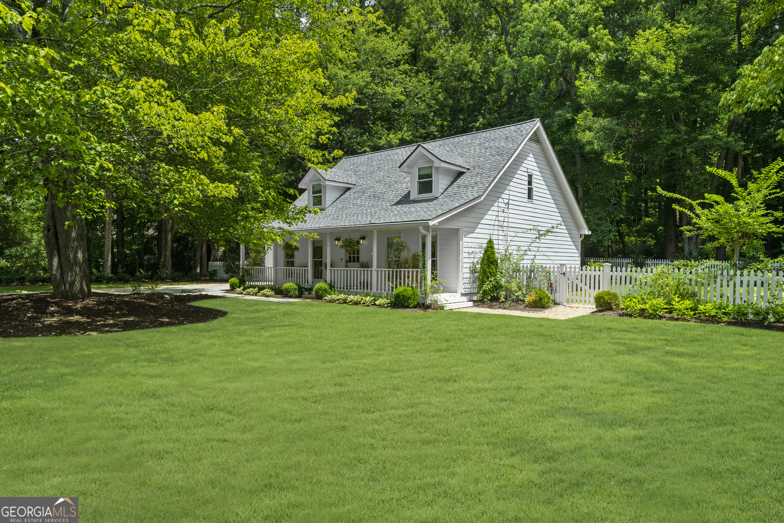 Welcome to your completely renovated haven in the heart of downtown Alpharetta, where charm meets modern sophistication on a sprawling .69-acre lot! This delightful 3br 2.5ba home offers the perfect blend of comfort and style. Step inside to discover stunning white oak wide plank hardwood floors that flow throughout the home, creating warmth and elegance in every room. The primary suite is conveniently located on the main level, spa like bathroom with floating vanities, frameless glass shower and designer lighting. The living room captivates with a vaulted ceiling and cozy wood-burning fireplace complete with gas starter. The open kitchen serves as the heart of the home, featuring stainless steel appliances, oversized island, designer tile, quartz countertops and a charming breakfast nook with bay windows that frame views of the beautifully landscaped outdoor entertaining area. A spacious dining area on the opposite side of the kitchen provides ample space for hosting family gatherings. Secondary level offers two bedrooms and a full bathroom, with ample storage and closet space. Completely redesigned landscape featuring boulder walls, pea gravel entertaining areas, complete irrigation system, lush Zoysia sod, mature trees, and plantings all enclosed within a quintessential white picket fence. Thoughtfully designed low-voltage lighting illuminates the home and yard, with enchanting firefly lights dancing among the trees from dusk to dawn. Enjoy a short stroll to your favorite restaurants and shops, welcome home!