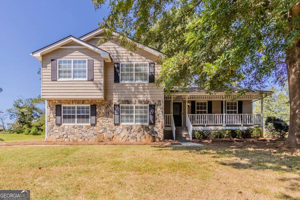 Welcome home to this charming split-level residence in the Monticello community. Offering 3 bedrooms and 2.5 bathrooms, this property features trey ceilings, bay windows, and a cozy family room with fireplace. The kitchen includes white cabinets, pantry storage, and an eat-in area that opens to the living space. Enjoy a spacious backyard with a deck, perfect for entertaining or quiet evenings outdoors. Additional highlights include a covered front porch, separate dining room, two-car garage, and professionally managed services. Conveniently located near schools, shopping, and quick access to I-75, this home blends comfort and convenience.