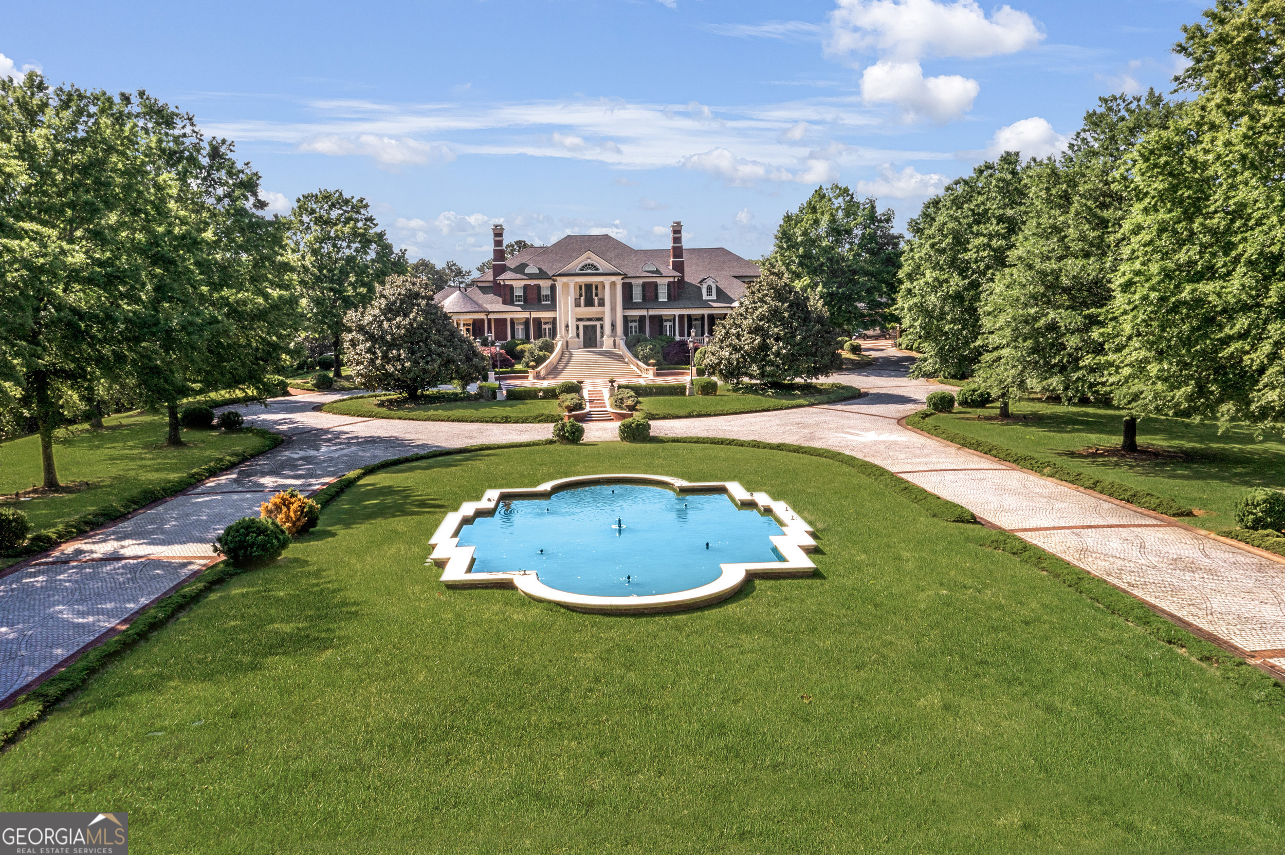 Introducing the most spectacular gated estate in Suwanee on over 14 acres with custom sophistication and style. This awe-inspiring property features expansive private grounds and endless options of entertainment and relaxation. You will enjoy 6 Full kitchens featuring Subzero and Viking appliances, combined with 2 kitchenettes. The main Kitchen features a large scullery and walk-in pantry with a remote-controlled pantry shelving system. There is a second full kitchen just steps away with access to the covered porch and outdoor kitchen. The primary suite on the main levels is the perfect retreat with a covered balcony, large fireplace, his and hers bathrooms and his and hers custom closets. Upstairs you will enjoy more entertainment spaces, a kitchen, private rooms all featuring ensuites and custom closets. In addition to a walkup attic with custom cabinetry throughout. The elevator can be used to access the 3-floors. The terrace level features a true theatre, large game room, full kitchen, fireplace, multiple French doors to the walkout pool area, large bedroom, sitting room and full bath with steam shower and barber area. The enormous, heated saltwater pool can be enjoyed all year around with a retractable cover. The large outdoor stone fireplace is a perfect place to relax and walk over to grab a game of basketball on the court. The pool house features a large area that is currently a gym with another kitchen and bath. The extensive gardens are just behind the pool house. The garage is equipped for over 10-cars with custom flooring, cabinetry and HVAC. Your guests can enjoy ultimate privacy in one of the multiple apartments. The estate's luxe interior is matched by its manicured exterior, with professionally landscaped gardens that bloom in vibrant colors throughout the seasons. The lush greenery leads you to the private lake, where you can enjoy serene moments fishing from the dock or a leisurely ride on a paddleboat. Two gated entrances provide convenience and security, making this property ideal for entertaining and valet parking for your guests. This extraordinary property is more than a home; it is a sanctuary designed for those who seek the ultimate in luxury living. With every imaginable amenity and an unparalleled level of craftsmanship, this estate is truly a masterpiece that must be experienced to be believed.