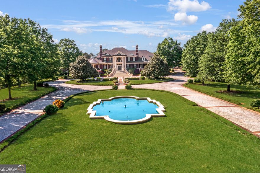 Introducing the most spectacular gated estate in Suwanee on over 14 acres with custom sophistication and style. This awe-inspiring property features expansive private grounds and endless options of entertainment and relaxation. You will enjoy 6 Full kitchens featuring Subzero and Viking appliances, combined with 2 kitchenettes. The main Kitchen features a large scullery and walk-in pantry with a remote-controlled pantry shelving system. There is a second full kitchen just steps away with access to the covered porch and outdoor kitchen. The primary suite on the main levels is the perfect retreat with a covered balcony, large fireplace, his and hers bathrooms and his and hers custom closets. Upstairs you will enjoy more entertainment spaces, a kitchen, private rooms all featuring ensuites and custom closets. In addition to a walkup attic with custom cabinetry throughout. The elevator can be used to access the 3-floors. The terrace level features a true theatre, large game room, full kitchen, fireplace, multiple French doors to the walkout pool area, large bedroom, sitting room and full bath with steam shower and barber area. The enormous, heated saltwater pool can be enjoyed all year around with a retractable cover. The large outdoor stone fireplace is a perfect place to relax and walk over to grab a game of basketball on the court. The pool house features a large area that is currently a gym with another kitchen and bath. The extensive gardens are just behind the pool house. The garage is equipped for over 10-cars with custom flooring, cabinetry and HVAC. Your guests can enjoy ultimate privacy in one of the multiple apartments. The estate's luxe interior is matched by its manicured exterior, with professionally landscaped gardens that bloom in vibrant colors throughout the seasons. The lush greenery leads you to the private lake, where you can enjoy serene moments fishing from the dock or a leisurely ride on a paddleboat. Two gated entrances provide convenience and security, making this property ideal for entertaining and valet parking for your guests. This extraordinary property is more than a home; it is a sanctuary designed for those who seek the ultimate in luxury living. With every imaginable amenity and an unparalleled level of craftsmanship, this estate is truly a masterpiece that must be experienced to be believed.
