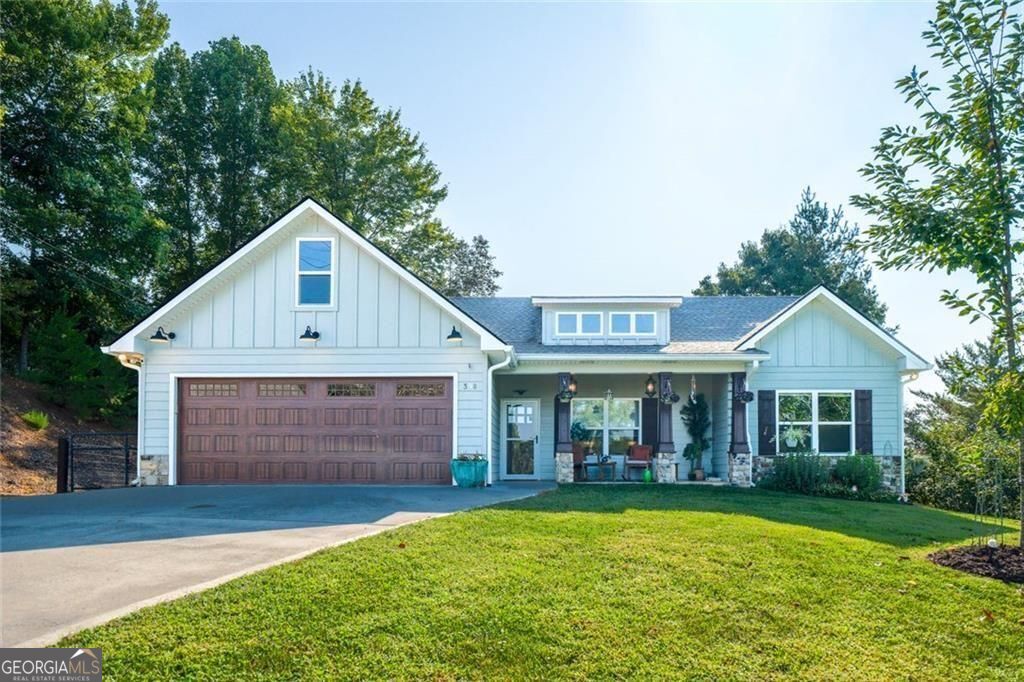This stunning stepless ranch in Ellijay, GA is not just a home-it's the lifestyle you've been waiting for. Perfectly blending modern farmhouse elegance with warm, inviting comfort, this one-of-a-kind retreat sits within city limits yet offers seasonal mountain views and a peaceful, private setting-all just a short stroll to downtown. Step inside and fall in love with the open great room, where soaring T&G wood ceilings, a sleek electric fireplace, and sunlit walls create the ultimate backdrop for both everyday living and unforgettable entertaining. The chef's kitchen is a showstopper, featuring a stainless steel farm sink, crisp white cabinetry, a statement wood island, and vent hood-all designed to impress and inspire. Your luxurious master suite is its own sanctuary: custom-organized walk-in closet, spa-worthy bath with subway-tile shower, freestanding soaking tub, and a double vanity accented with timeless shiplap. Guests will feel pampered, too, with two serene bedrooms and a stylish full bath. Details matter-and this home has them all: a barn door laundry room, two-car garage, concrete driveway, level yard, and that picture-perfect covered porch made for morning coffee and evening wine with a view. Opportunities like this do not come twice. This is more than a home-it's the one you've been dreaming of. Schedule your showing today before someone else calls it theirs.