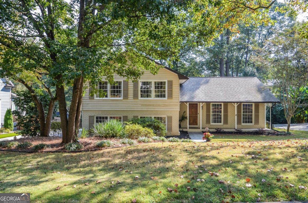 On this tree-lined street, daily life unfolds with ease: the morning light pouring through the sunroom's vaulted windows, the scent of dinner drifting from the kitchen as the family gathers around the table, laughter carrying from the backyard deck on summer evenings. This home is not just where you live, but where today's routines turn into tomorrow's cherished memories. This renovated 4-bedroom, 3-bath home sits on a level lot with a 2-car garage and combines thoughtful updates with everyday functionality. The eat-in kitchen features granite counters, white cabinetry, pantry storage, and stainless appliances-including a 36-inch Fisher & Paykel 6-burner gas range with hood vent. A main floor bedroom with an adjacent full bath (custom tile walk-in shower with glass rolling door) provides flexibility for guests or multigenerational living. Upstairs, the primary suite offers generous space and an updated bath with heated floors, double vanity, and walk-in shower. Two additional bedrooms share an updated hall bath. The home's light-filled layout includes a fireside family room, oversized dining room with built-in bookshelves, and a vaulted sunroom, providing spaces that adapt to everyday living and special occasions. Recent improvements include vinyl dual-paned windows, freshly painted exterior with warranty, a new water heater, a 5-year-old roof, and a termite bond through Arrow Exterminators -updates and maintenance that bring ease and peace of mind. An optional neighborhood swim and tennis membership adds another layer of community connection and recreation. And with quick access to freeways, shopping, dining, schools, and Gwinnett County's parks, trails, and recreation areas, the conveniences of daily life are always close at hand. Here, practicality meets possibility-giving you the freedom to focus on the moments that matter most.