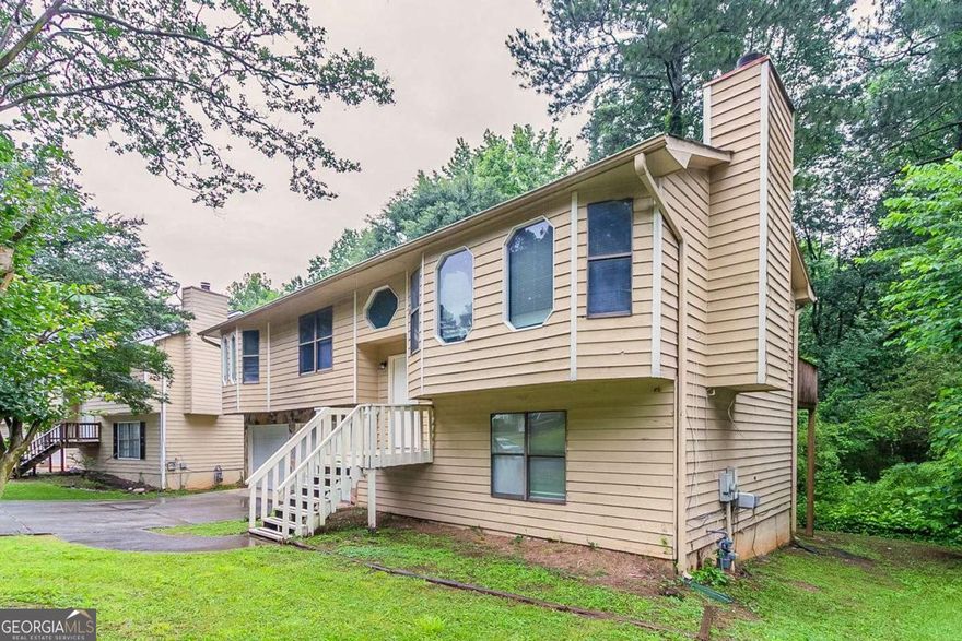 Welcome to this charming split-level 3-bedroom, 3-bathroom home with great curb appeal and a spacious 2-car garage! The upper level features an open flow from the kitchen, dining, and living area with bright white cabinets, a cozy fireplace, and large windows that flood the space with natural light. Generously sized bedrooms offer comfort and flexibility, including an additional bonus room perfect for an office, playroom, or media space.    Enjoy outdoor living in the serene backyard with a deck overlooking the landscaped yard-ideal for relaxing or entertaining. Don't miss the opportunity to make this light-filled, versatile home yours! Reserve your tour today! This home has been virtually staged to illustrate its potential.