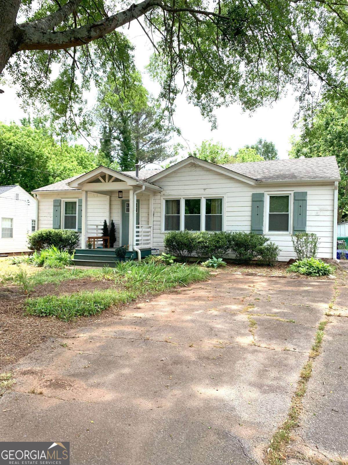 Welcome to this charming home, just minutes from Belvedere Park, Avondale Estates, and Downtown Decatur! This home blends 1950s design with modern amenities. You'll enjoy updates such as a full plumbing replacement from the street throughout the home, updated electrical wiring and fuse box, the addition of a covered front porch and screened deck, an expanded living/dining room, a renovated kitchen and open breakfast room, an updated bathroom, new windows, and hardwood floors throughout. This home is solid with great bones but needs a little cosmetic TLC to truly shine. Step inside this charmer to a large living room featuring natural light from a pretty picture window. The dining area boasts an original 1950s light fixture. The updated kitchen includes white appliances, granite countertops, and subway tiles. An original 1950s door leads to a huge screened-in deck, perfect for relaxing or entertaining with family and friends! The rear deck overlooks a large, fenced backyard, offering plenty of room to garden or simply enjoy being outdoors. There's even a small storage barn and a chicken coop! Come see this home today.